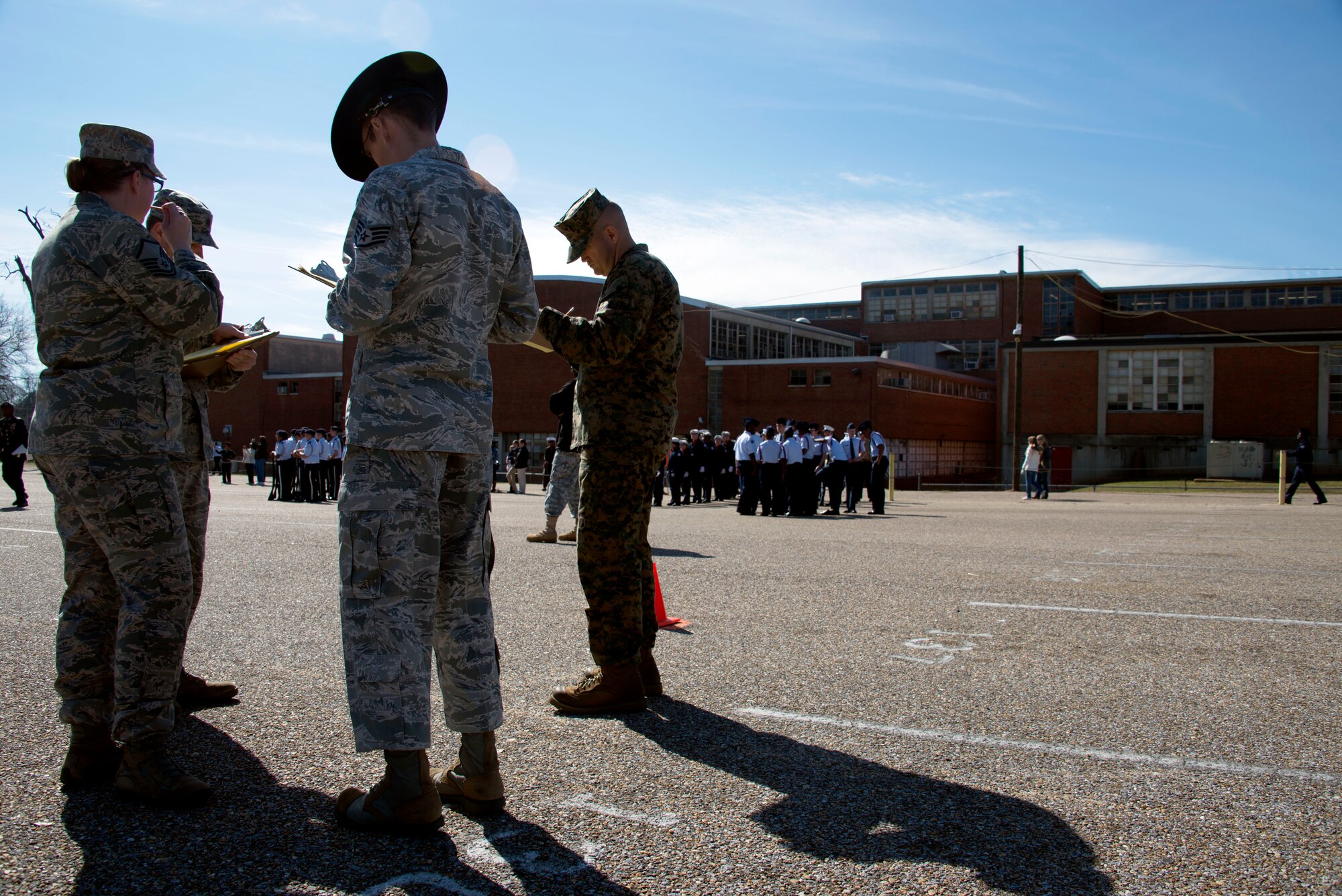 Airmen from Maxwell-Gunter huddle up to finalize the score of a Junior ROTC team’s performance at the Larry Jones Invitational Drill Meet hosted by Robert E. Lee High School, Montgomery, Alabama, Jan. 31, 2015. Approximately 50 Airmen volunteered to judge the cadets on their performance and show their support. (U.S. Air Force photo by Airman 1st Class Alexa Culbert/Cleared)