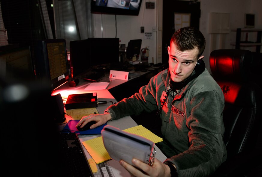 Airman 1st Class Kodi Tomassi, 86th Airlift Wing Command Post junior emergency actions controller, looks over an emergency management checklist at Ramstein Air Base, Germany, Feb. 5, 2015. Tomassi is one of a small number of Airmen sealed behind security and blast doors that support the largest population of Americans outside the U.S. with emergency response coordination. (U.S. Air Force photo/Senior Airman Armando A. Schwier-Morales)