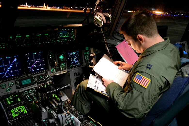 U.S. Air Force Capt. Matt Kettler, a C-17 Globemaster III transport aircraft pilot assigned to the 17th Airlift Squadron, Joint Base Charleston, South Carolina, conducts preflight checks during an Emergency Deployment Readiness Exercise at Green Ramp, Pope Army Airfield, North Carolina, Jan. 27, 2015. Five hundred U.S. Army paratroopers from the 2nd Brigade Combat Team, 82nd Airborne Division, were airdropped onto Wright Army Airfield, Fort Stewart, Georgia, from five C-17 transport aircraft 18 hours after notification. As the nucleus of the nation's Global Response Force, the 82nd Airborne Division provides a strategic hedge for combatant commanders with a responsive, agile and operationally significant response force that is flexible in size and composition to accomplish missions anywhere in the world. Air Mobility Command's participation also illustrates the critical partnership between Mobility Air Forces and the U.S. Army by exercising Joint Forcible Entry: the capability of rapidly introducing forces into hostile environments to conduct operations—whether combat or humanitarian support. (U.S. Air Force photo/Marvin Krause)