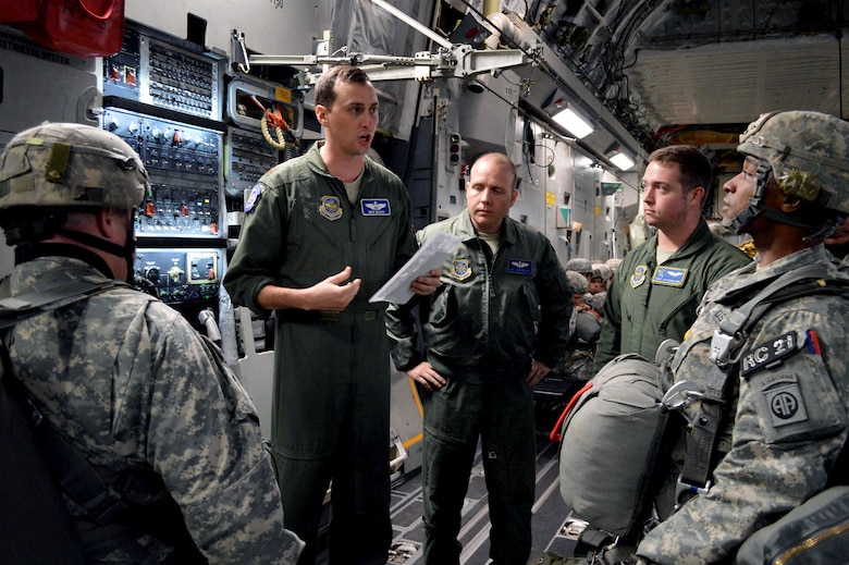U.S. Air Force Maj. Ben Wood, a C-17 Globemaster III aircraft pilot assigned to the 17th Airlift Squadron, Joint Base Charleston, South Carolina, conducts a mission briefing with U.S. Army paratroopers from the 2nd Brigade Combat Team, 82nd Airborne Division, on Green Ramp, Pope Army Airfield, North Carolina, Jan. 27, 2015, during an Emergency Deployment Readiness Exercise. Five hundred paratroopers were airdropped onto Wright Army Airfield, Fort Stewart, Georgia, from five C-17 transport aircraft 18 hours after notification. As the nucleus of the nation's Global Response Force, the 82nd Airborne Division provides a strategic hedge for combatant commanders with a responsive, agile and operationally significant response force that is flexible in size and composition to accomplish missions anywhere in the world. Air Mobility Command's participation also illustrates the critical partnership between Mobility Air Forces and the U.S. Army by exercising Joint Forcible Entry: the capability of rapidly introducing forces into hostile environments to conduct operations—whether combat or humanitarian support. (U.S. Air Force photo/Marvin Krause)