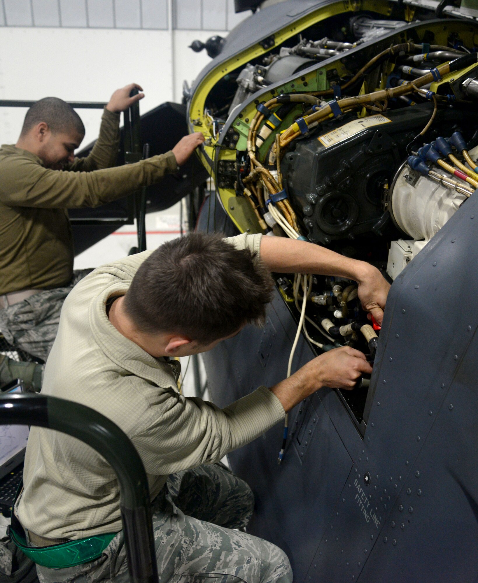 U.S. Air Force Staff Sgt. Joel Miller, front, from Goshen, Ind., and U.S. Air Force Matthew Rogers, from Miami, Fla., both 352nd Special Operations Maintenance Squadron electrical environmental systems technicians, repair wiring on a CV-22B Osprey Jan. 29, 2015, on RAF Mildenhall, England. The CV-22 is a tiltrotor aircraft that combines the vertical takeoff, hover and vertical landing qualities of a helicopter with the long-range, fuel efficiency and speed characteristics of a turboprop aircraft. Its mission is to conduct long-range infiltration, exfiltration and resupply missions for special operations forces. Vital to the special operations mission, maintainers are prepared to fix the aircraft when necessary ensuring the Ospreys are ready to fly at all times. (U.S. Air Force photo by Senior Airman Kate Maurer/Released)