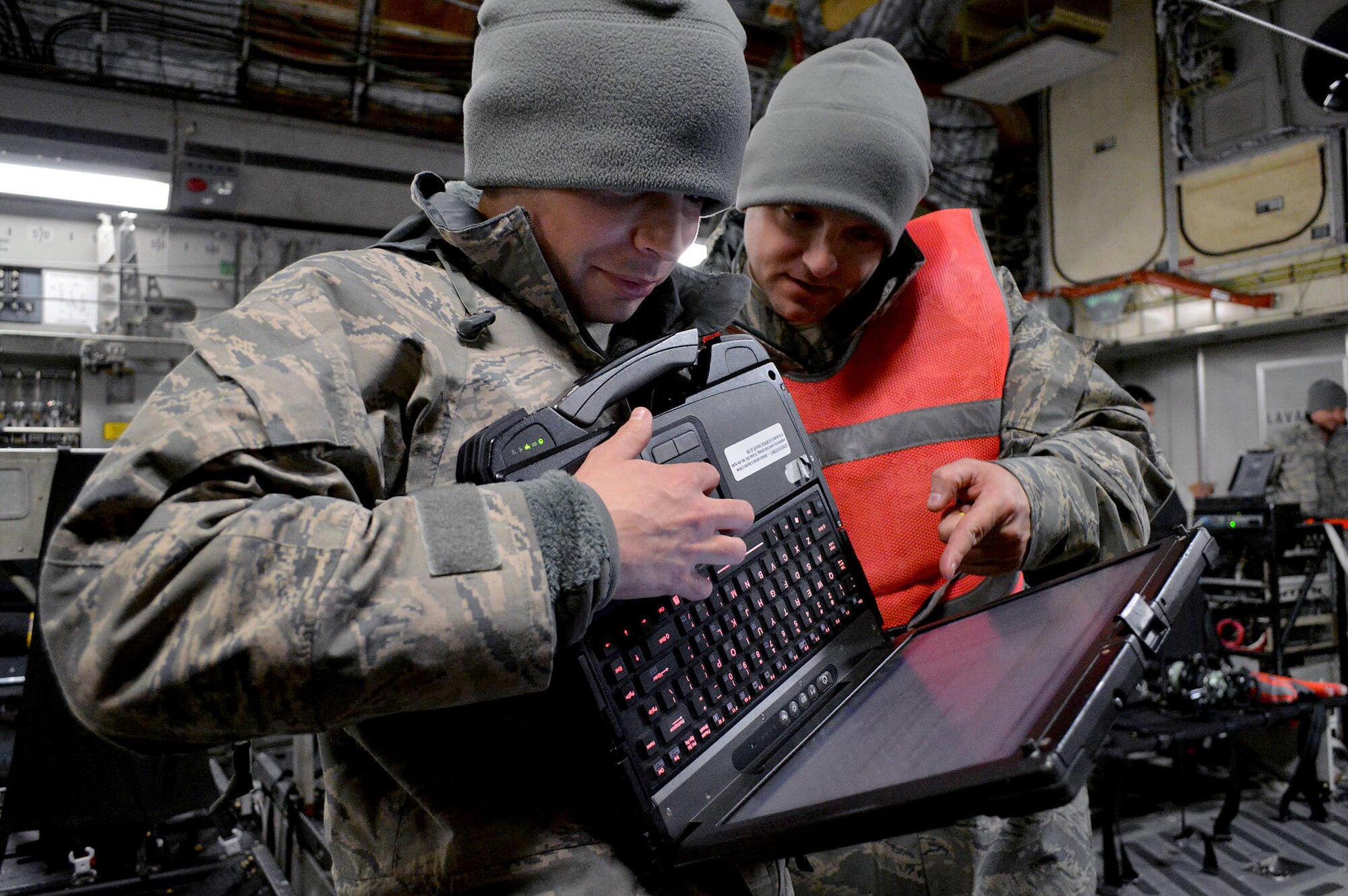 U.S. Air Force Staff Sgt. Joel Hamlet, left, an aircraft electrical and navigation systems craftsman and Staff Sgt. Michael Kozak, right, an aircraft communications and navigation systems craftsman, both from the 43rd Aircraft Maintenance Squadron, Pope Army Airfield, North Carolina, review C-17 Globemaster III aircraft technical orders during an Emergency Deployment Readiness Exercise on Jan. 27, 2015. By interacting and working closely with their joint partners, Mobility Airmen are able to develop refinements to processes and procedures that can potentially enhance the effectiveness of real-world operations. (U.S. Air Force photo/Marvin Krause)