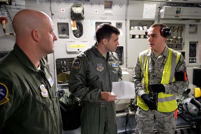 U.S. Air Force Airman 1st Class Mychailjo Nepip, right, a passenger services agent from the 3rd Aerial Port Squadron, Pope Army Airfield, North Carolina, coordinates passenger-loading planning with Staff Sgt. Andrew Reilly, middle, and Tech. Sgt. Jason Hoffman, left, both from the 14th Airlift Squadron, Joint Base Charleston, South Carolina, during an Emergency Deployment Readiness Exercise on Green Ramp, Pope Army Airfield, North Carolina, Jan. 27, 2015. The Emergency Deployment Readiness Exercise assesses the 82nd Airborne Division’s deployment readiness tasks for a no-notice deployment—including alert, outload procedures, and deployment—tasks that are necessary to their mission success as the Joint Forcible Entry component of the nation's Global Response Force. Air Mobility Command's participation also illustrates the critical partnership between Mobility Air Forces and the U.S. Army by exercising Joint Forcible Entry: the capability of rapidly introducing forces into hostile environments to conduct operations—whether combat or humanitarian support. (U.S. Air Force photo/Marvin Krause) 