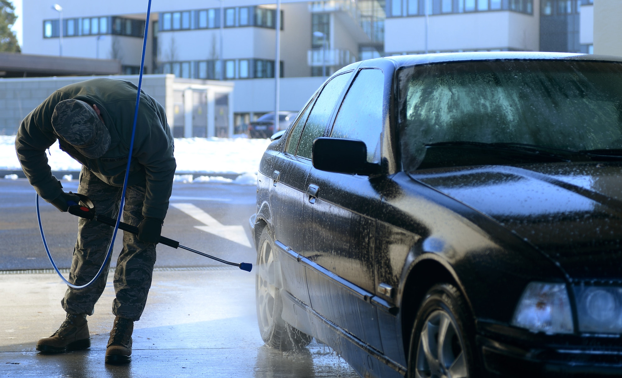 A Spangdahlem Airman washes his car at the newly opened self-service carwash on Spangdahlem Air Base, Germany, Feb. 4, 2015. The carwash also offers vacuum cleaner stations. (U.S. Air Force photo by Airman 1st Class Luke Kitterman/Released)