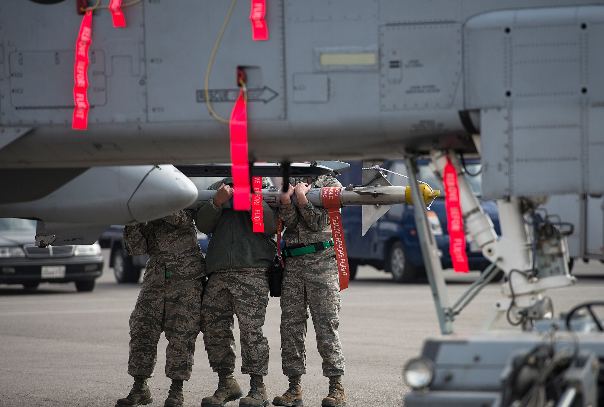 The 25th Aircraft Maintenance Unit load crew team balances a missile while trying to place it onto an A-10 during a quarterly weapons load crew competition Feb. 6, 2015, at Osan Air Base, Republic of Korea. The competition allows teams to practice their readiness abilities in a competitive environment, while helping reinforce stability in the ROK. (U.S. Air Force photo by Staff Sgt. Jake Barreiro)