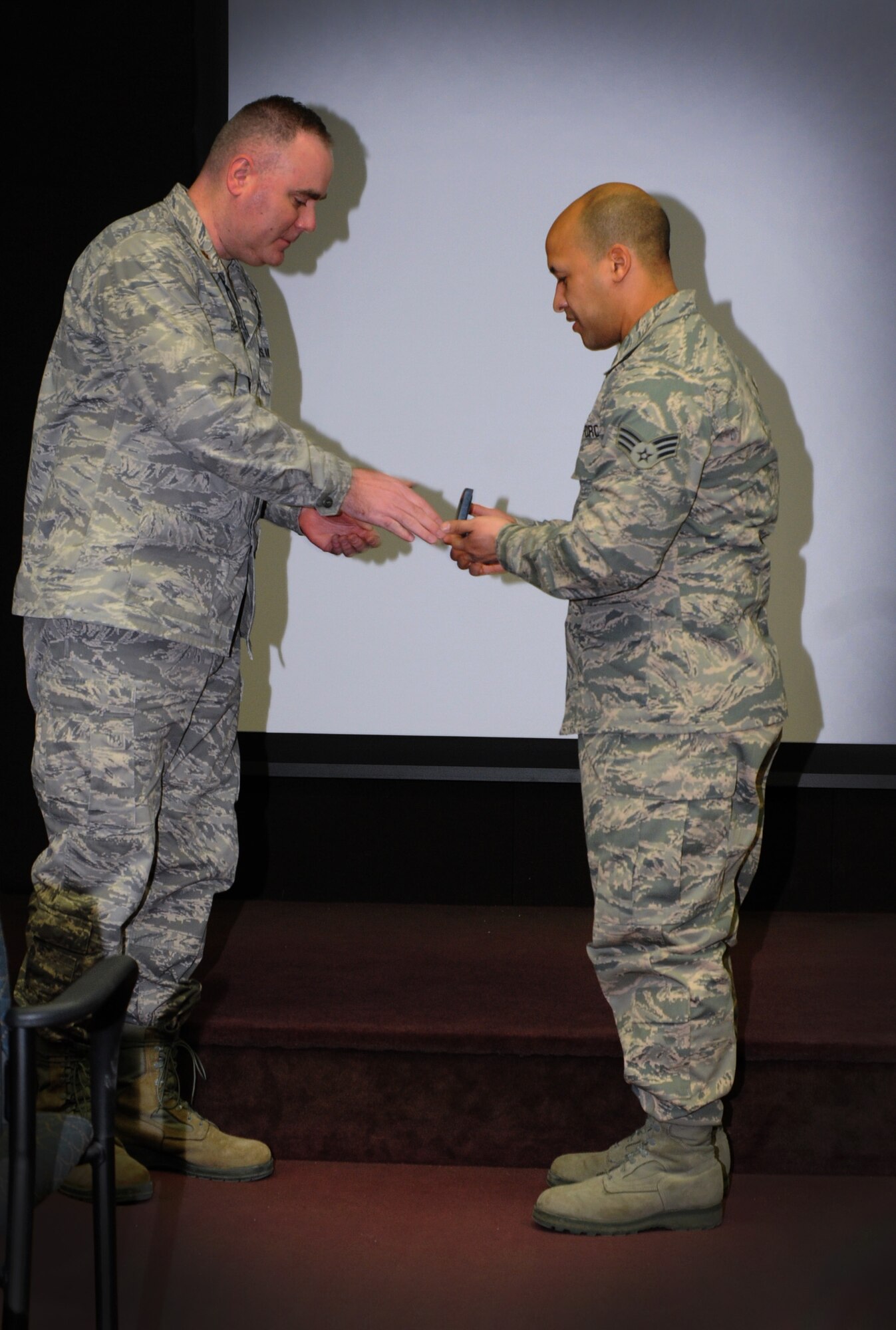Senior Airman Brandon Glover, 111th Operation Support Squadron cyber operations technician, receives a coin from Major James Best of the 111th Attack Wing, during their commander’s call Feb. 7, 2015, Horsham Air Guard Station, Pa. The coin was given to Glover as part of a reenlistment recognition program sponsored by the National Guard Bureau (U.S. Air National Guard photo by Tech. Sgt. Andria J. Allmond/Released)
