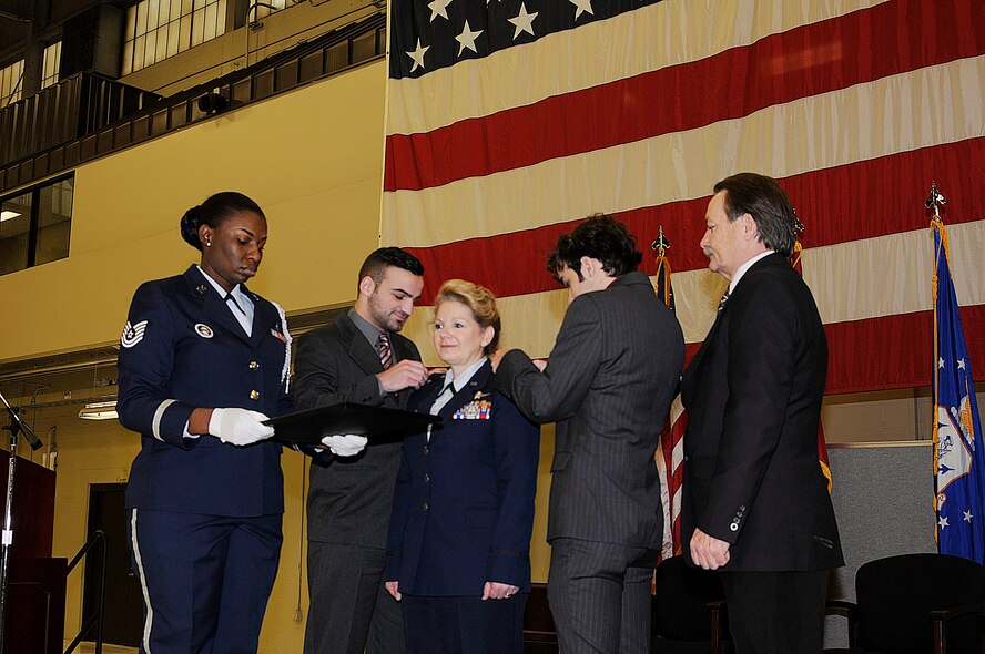 Col. Tenise Gardner stands at attention as her sons, Ryan (left) and Evan Gardner, pin on the rank of colonel as
her husband, Dr. William Gardner, observes Jan. 11, 2015, during her promotion ceremony held at Ebbing Air
National Guard Base, Fort Smith, Ark. Gardner first enlisted in the 188th in 1987 as an information manager and
received her commission in 1991. This marks the second time in wing history that a female has been promoted
to the rank of colonel. Tech. Sgt. Yolanda Winston, 188th Medical Group member, is the proffer during the ceremony.
(U.S. Air National Guard photo by Staff Sgt. Hannah Dickerson/released)