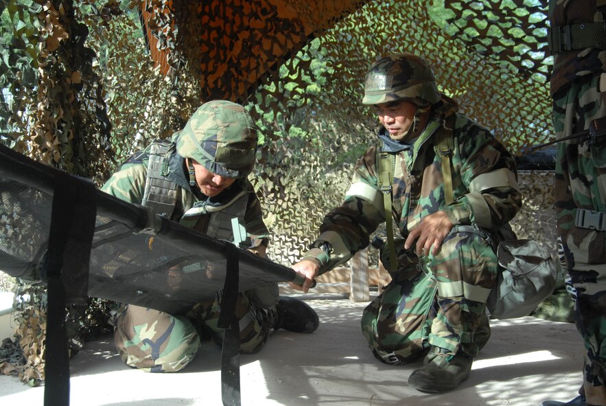 U.S. Air Force Master Sgt. Jose M. Lujan and Master Sgt. Daryl Dumlao, from the Hawaii Air National Guard 154th Civil Engineering Squadron, prepare a litter to transport a casualty during a Chemical Biological Radiological Nuclear (CBRN) exercise at Joint Base Pearl Harbor-Hickam, Hawaii, Feb. 5, 2015. The exercise is part of the Commanders Inspection Program (CCIP) which includes objectives that evaluate Self Aid Buddy Care capabilities in a CBRN working environment. (U.S. Air National Guard photo by A1C Robert Cabuco)