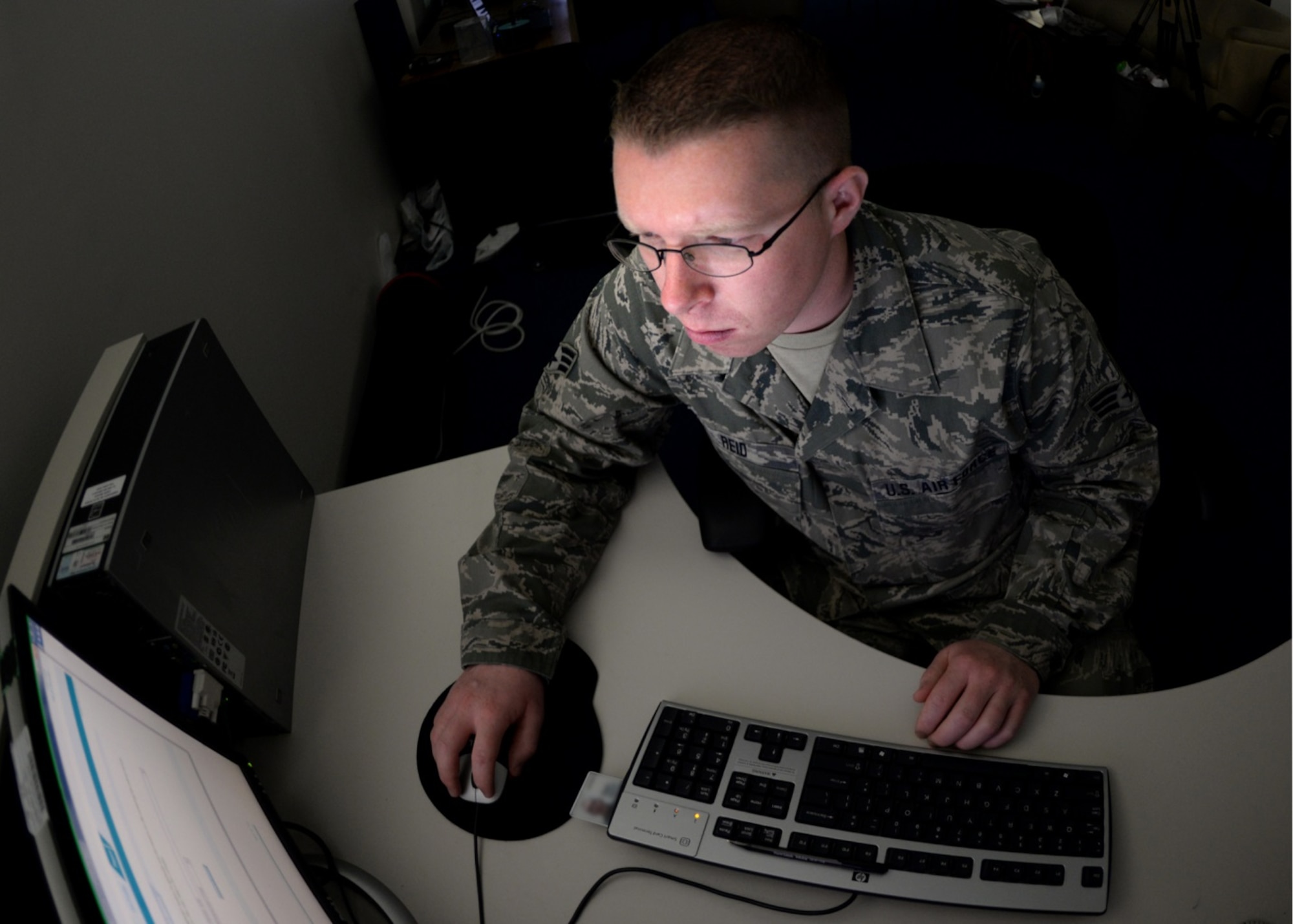 U.S. Air Force Senior Airman Wayne Reid, operations administrative assistant, verifies documents on the Defense Travel System in the 506th Expeditionary Air Refueling Squadron, Andersen Air Force Base, Guam, Jan. 29, 2015. Reid was deployed with the Operations Group from the 157th Air Refueling Wing, N.H., to the 506 EARS. (U.S. Air National Guard photo by Senior Airman Kayla McWalter/RELEASED)