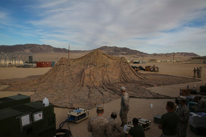 Marines set up camouflage netting as the first step in forming a combat operations center Jan. 16, at the Marine Air Ground Combat Center Twentynine Palms, for Integrated Training Exercise 2-15. A COC is where the command element can monitor units and make decisions. The 4th Marine Regiment was designated as the Special Purpose Marine Air-Ground Task Force’s command element. Marines setting up the COC are with 4th Marines,  3rd Marine Division, III Marine Expeditionary Force. 