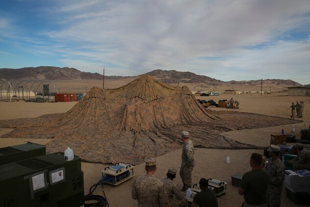 Marines set up camouflage netting as the first step in forming a combat operations center Jan. 16, at the Marine Air Ground Combat Center Twentynine Palms, for Integrated Training Exercise 2-15. A COC is where the command element can monitor units and make decisions. The 4th Marine Regiment was designated as the Special Purpose Marine Air-Ground Task Force’s command element. Marines setting up the COC are with 4th Marines,  3rd Marine Division, III Marine Expeditionary Force. 