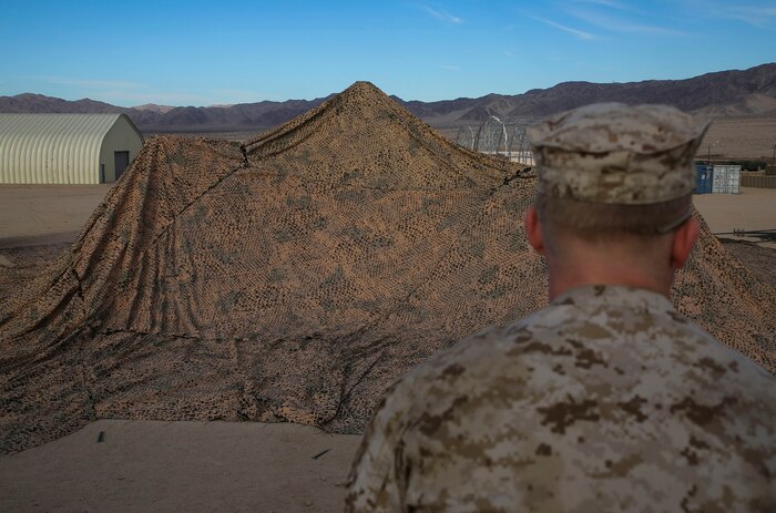 Sgt. Randall W. Lester guides junior Marines setting up the combat operations center Jan. 16, at Marine Air Ground Combat Center Twentynine Palms, for Integrated Training Exercise 2-15. Lester stood back to make sure the netting was placed in the correct location to fit all of the tents for the COC. The COC is where the command element monitors units and is a decision making hub. Lester, a Phoenix, Arizona, native, is an assistant fires chief for 4th Marine Regiment, 3rd Marine Division, III Marine Expeditionary Force. 