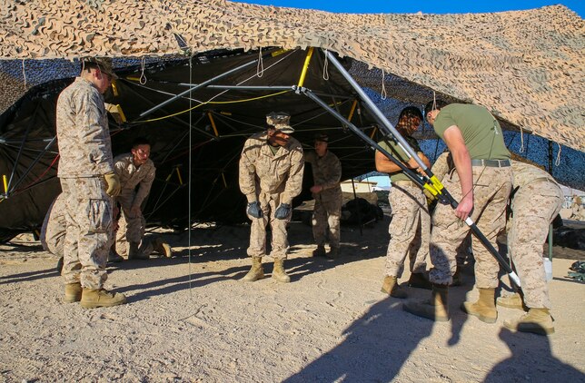 Marines set up the tents for the combat operations center for Integrated Training Exercise 2-15 after emplacing camouflage netting Jan. 16 at Marine Air Ground Combat Center Twentynine Palms. Putting up the netting first, then the tents makes set-up a lot easier, according to Staff Sgt. Absalon A. Cabrera, an operations assistant with 4th Marine Regiment, 3rd Marine Division, III Marine Expeditionary Force, and Lost Angeles, California, native. The Marines working are also with 4th Marines. 