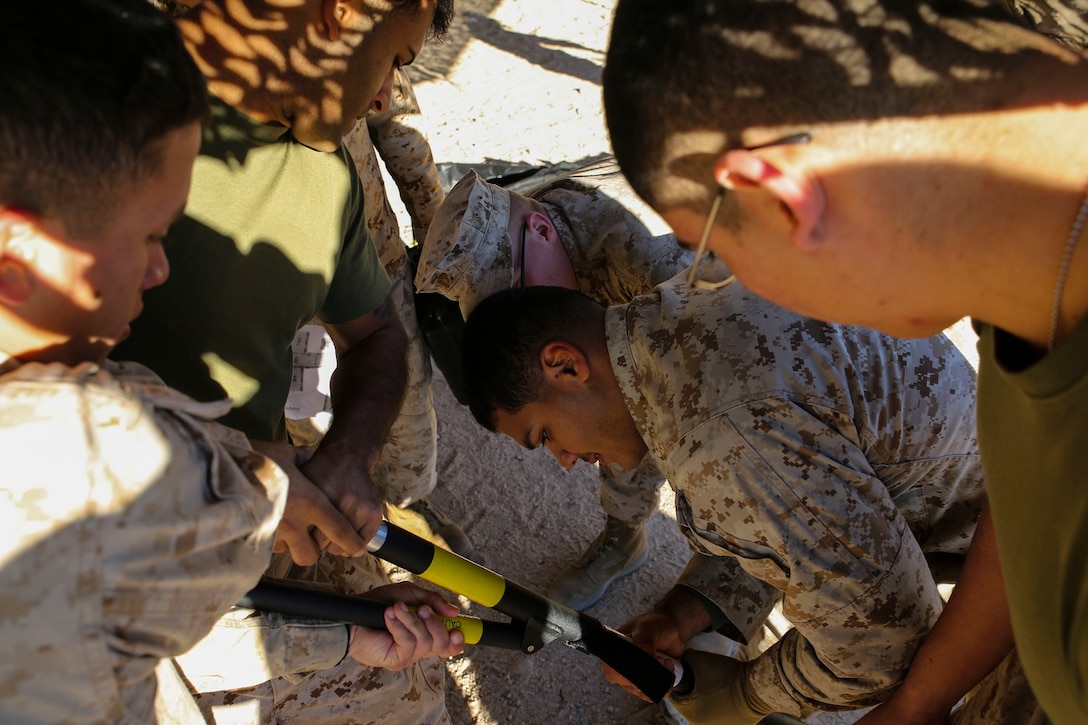 Marines extend the legs of a canopy-style tent as part of the combat operations center for Integrated Training Exercise 2-15 Jan. 16 at Marine Air Ground Combat Center Twentynine Palms. It is important to set up the camouflage netting before putting up the tents because it makes the process a lot faster, according to Staff Sgt. Absalon A. Cabrera, an operations assistant with 4th Marine Regiment, 3rd Marine Division, III Marine Expeditionary Force, and Los Angeles, California, native. Marines working on the tent are also with 4th Marines.