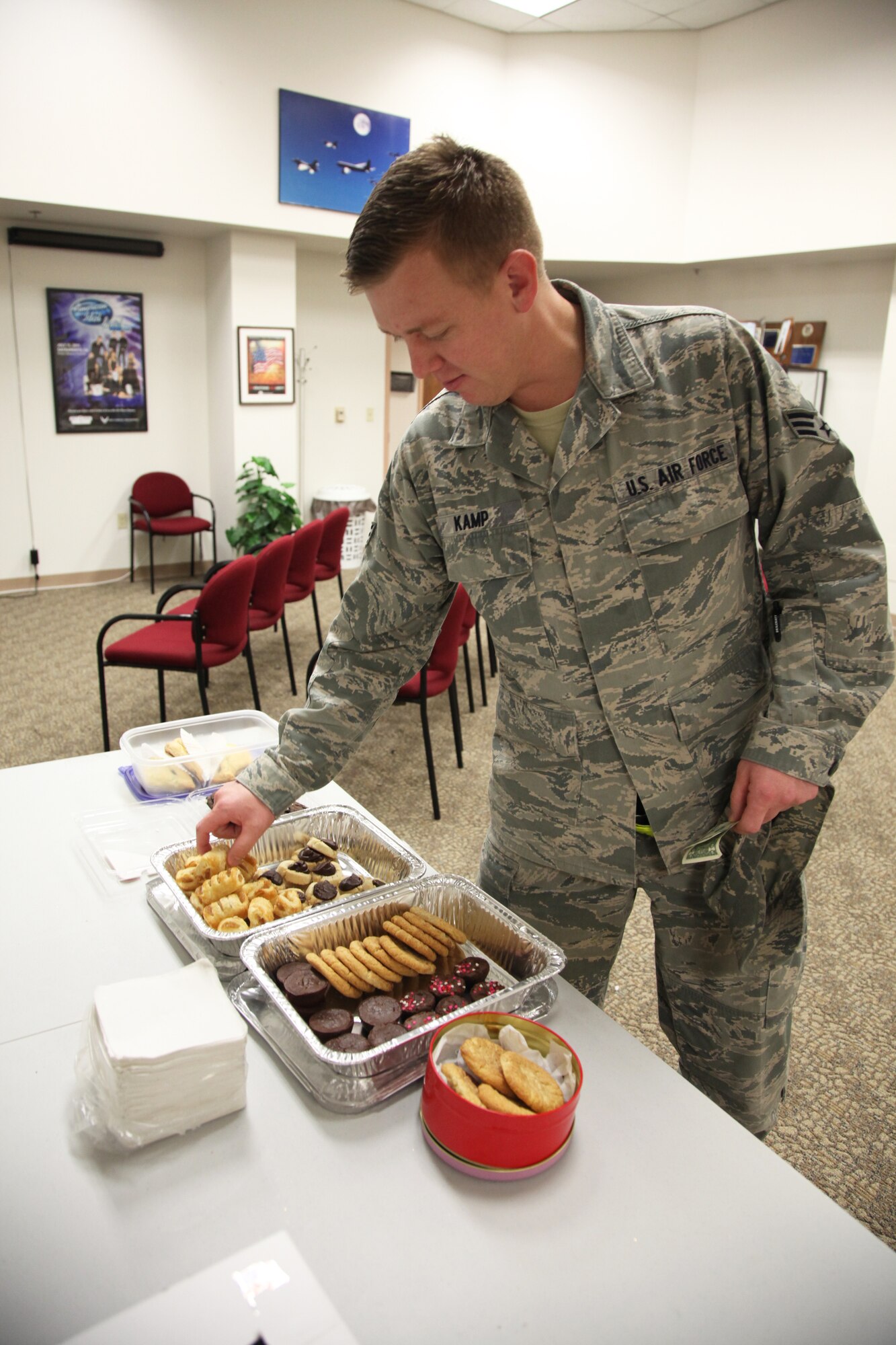 Senior Airman Joshua Kamp, 13th Reconnaissance Squadron knowledge operations manager, purchases some baked goods during the Rising Six’s bake sale, Feb. 7, at the 940th Wing headquarters, Beale Air Force Base, Calif. Proceeds of the bake sale go towards the wing picnic and other wing related activities. (U.S. Air Force photo by Tech. Sgt. Kenneth McCann/Released)