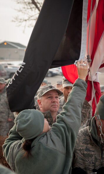 Lt. Col. Donald Kom, 934th Airlift Wing, holds the flag back so that Tech. Sgt. Kristin Franzoni can unclip it from the flagpole. Members of the 934 AW staff performed the retreat ceremony Saturday of the Unit Training Assembly weekend at the Minneapolis-St. Paul Air Reserve Station, Minn.  (U.S. Air Force photo by Shannon McKay/Released)