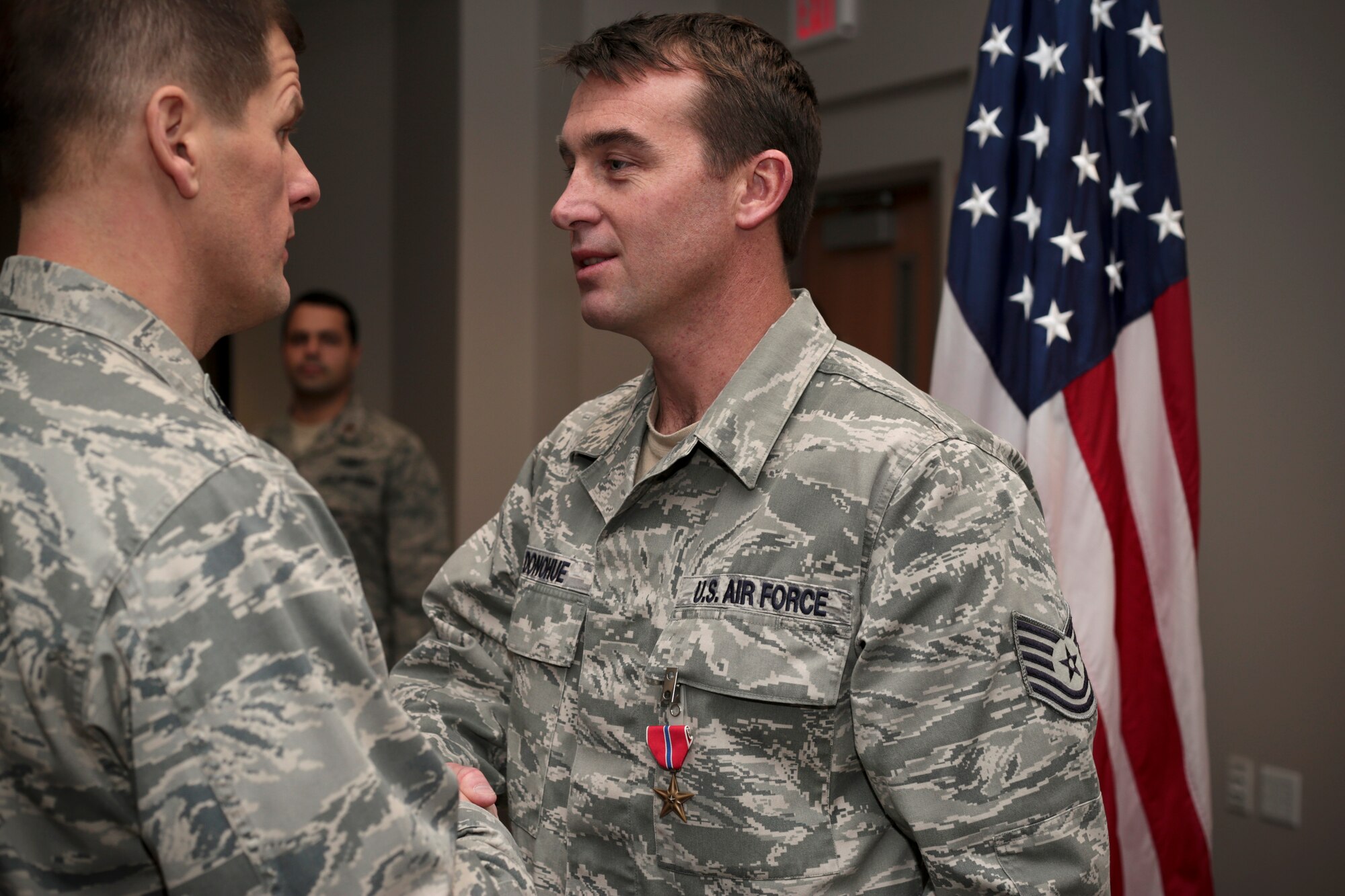 A picture of U.S. Air Force Tech. Sgt. Christopher Donohue being congratulated by Col. Kerry M. Gentry, commander of the 177th Fighter Wing, after receiving the Bronze Star Medal.