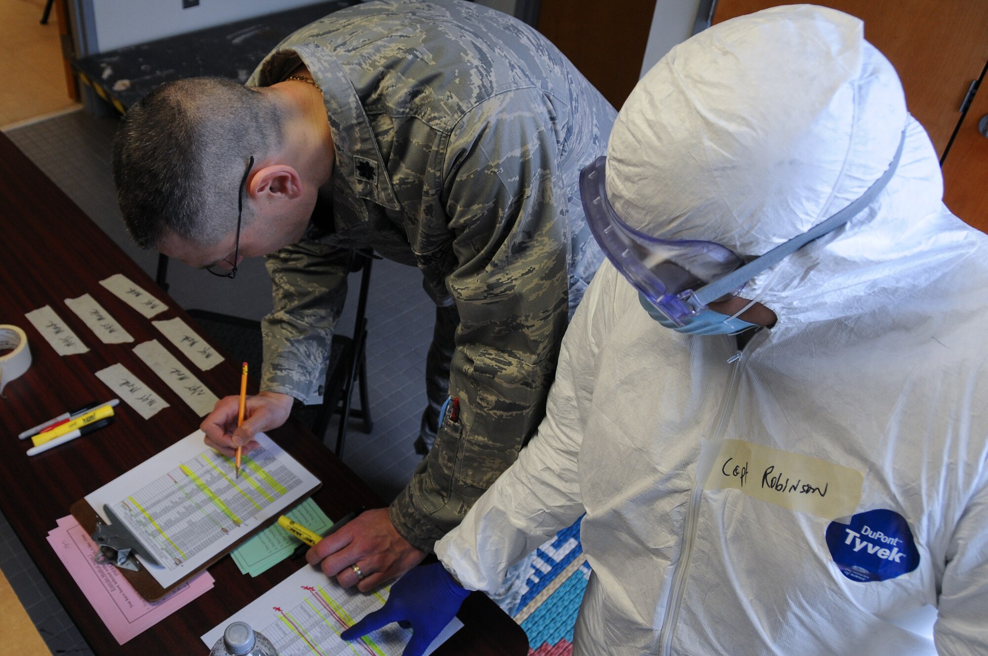 A picture of U.S. Air Force Lt. Col. Eric Erickson and Capt. Lisa Robinson with the New Jersey Air National Guard's 177th Fighter Wing Medical Group in Egg Harbor Township, N.J., looking over information on the number of simulated exposures and infections.