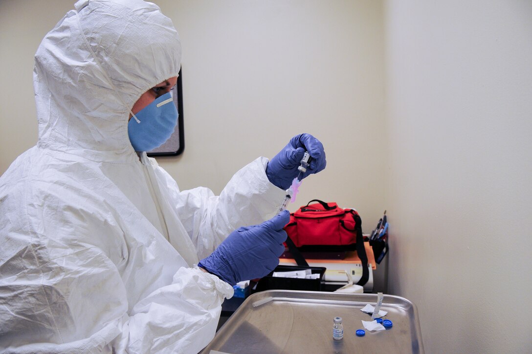 U.S. Air Force Senior Airman Jennifer Heller with the New Jersey Air National Guard's 177th Fighter Wing Medical Group in Egg Harbor Township, N.J., prepares to give a shot during the base's Disease Containment Exercise. The base simulated responding to an Ebola outbreak and paired it with giving flu and Hepatitis B shots Feb. 8, 2015. (U.S. Air National Guard photo by Airman 1st Class Amber Powell)