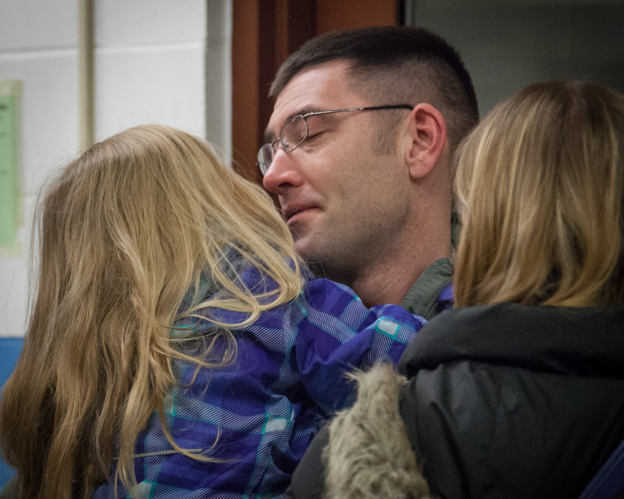 Tech. Sgt. Jesse Werner, 27th Aerial Port Squadron, leans to give his daughter a kiss during a farewell ceremony before he deploys for the coming months.  Airmen from the 27 APS said goodbye to family, friends, and fellow Airmen as they departed for the airport February 7, heading to Southwest Asia.  (U.S. Air Force photo by Shannon McKay/Released)