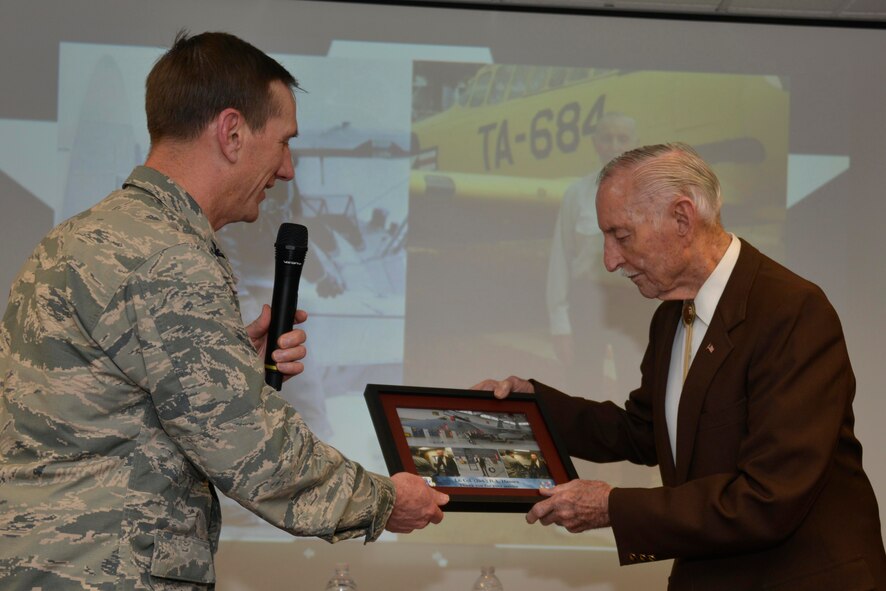 Col. Clay Garrison, 144th Fighter Wing commander, presents Lt. Col. (ret.) B.A. Hansen with a token of appreciation after the Wing Heritage Event Feb. 7. Hansen was the honored guest speaker at the event where he shared stories and experiences about his career in the Air Force. Hansen retired after 27 years and more than 12,000 flying hours. (Air National Guard photo by Senior Airman Klynne Pearl Serrano)