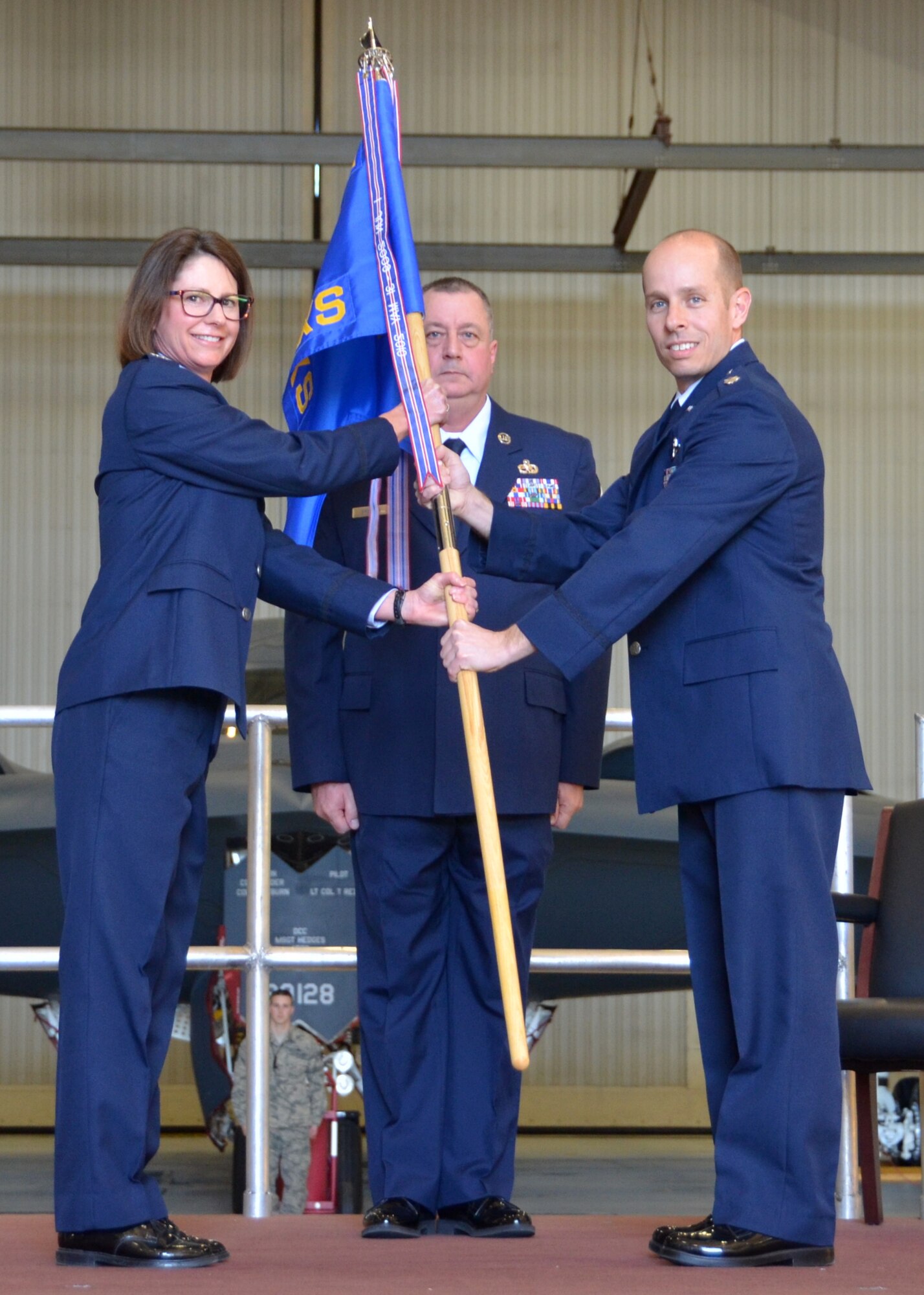 Lt. Col. Matthew Calhoun accepts the 131st Aircraft Maintenance Squadron guidon from Col. Kimbra Sterr, 131st Maintenance Group commander, during Calhoun’s Assumption of Command ceremony at Whiteman Air Force Base, Mo., Feb. 7, 2015.  