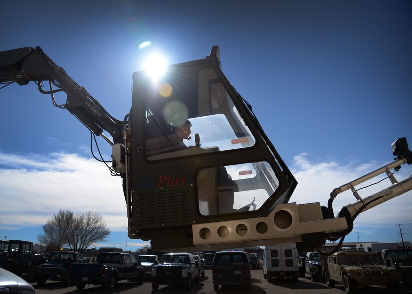 Airman 1st Class Krystal Magallanes, 27th Special Operations Logistics Readiness Squadron vehicle management apprentice, is lifted in a deicer Feb. 5, 2015 at Cannon Air Force Base, N.M. The vehicle is used to remove snow and ice from aerial assets during winter months. (U.S. Air Force photo/Staff Sgt. Alexxis Mercer)