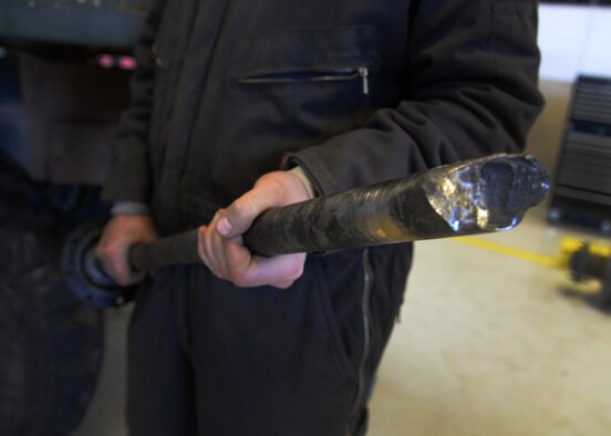 Airman 1st Class Joshua Davis, 27th Special Operations Logistics Readiness Squadron fire truck mechanic, holds up a broken real axle from an out-of-service M35 fire truck Feb. 5, 2015 at Cannon Air Force Base, N.M. This is one of the issues limiting functionality of the emergency response vehicle. (U.S. Air Force photo/Staff Sgt. Alexxis Mercer)