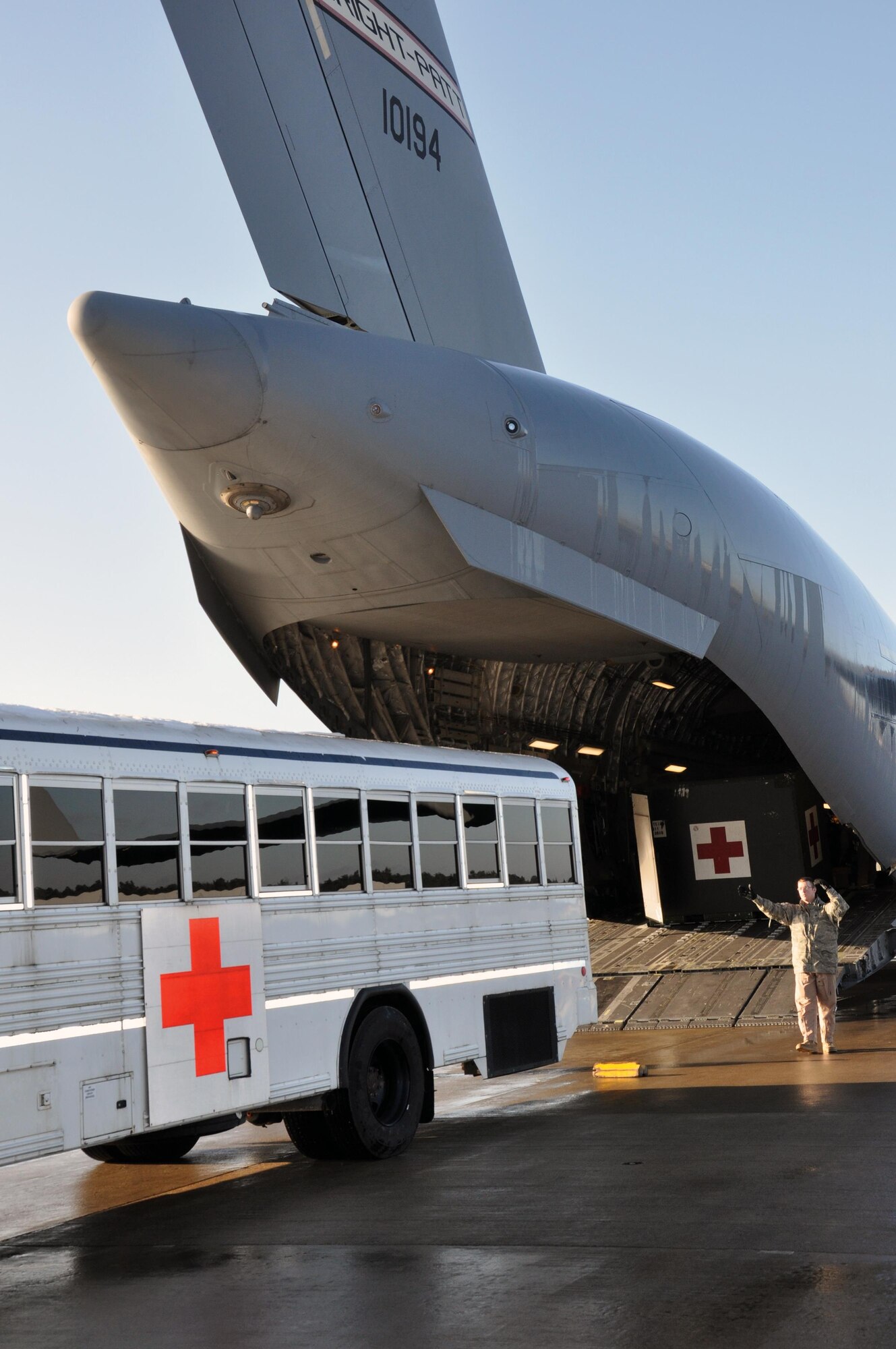 RAMSTEIN AIR BASE, Germany – Tech. Sgt. Travis Egger, 89th Airlift Squadron loadmaster, directs a bus of wounded warriors from the 86th Contingency Aeromedical Staging Facility at Ramstein Air Base toward a 445th Airlift Wing C-17 Globemaster III bound for Joint Base Andrews, Maryland Jan. 4, 2015. (U.S. Air Force photo/Capt. Elizabeth Caraway)
