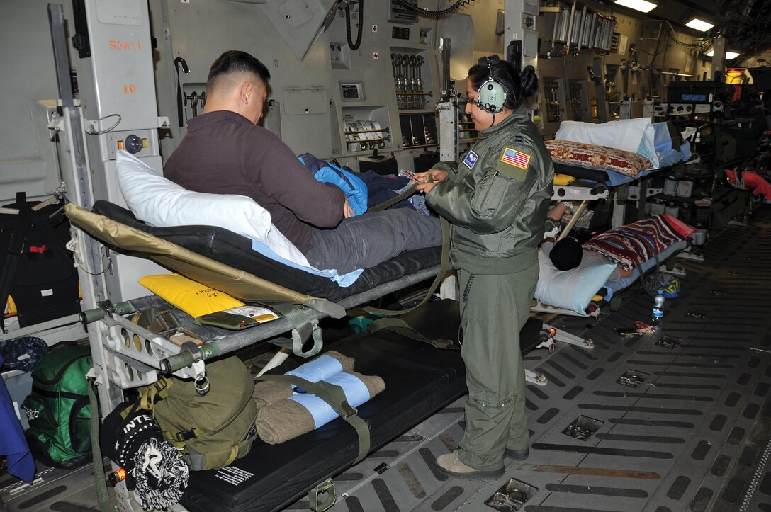 RAMSTEIN AIR BASE, Germany – Capt. Daisy Martinez, 86th Aeromedical Evacuation Squadron nurse, assists Maj. Stephen Ang, United States Army, during his Jan. 4, 2015 flight from Ramstein Air Base, Germany, to Joint Base Andrews, Maryland. Martinez stated that, of all the aircraft they use for aeromedical evac missions, the “C-17 is the most comfortable.” (U.S. Air Force photo/Capt. Elizabeth Caraway)
