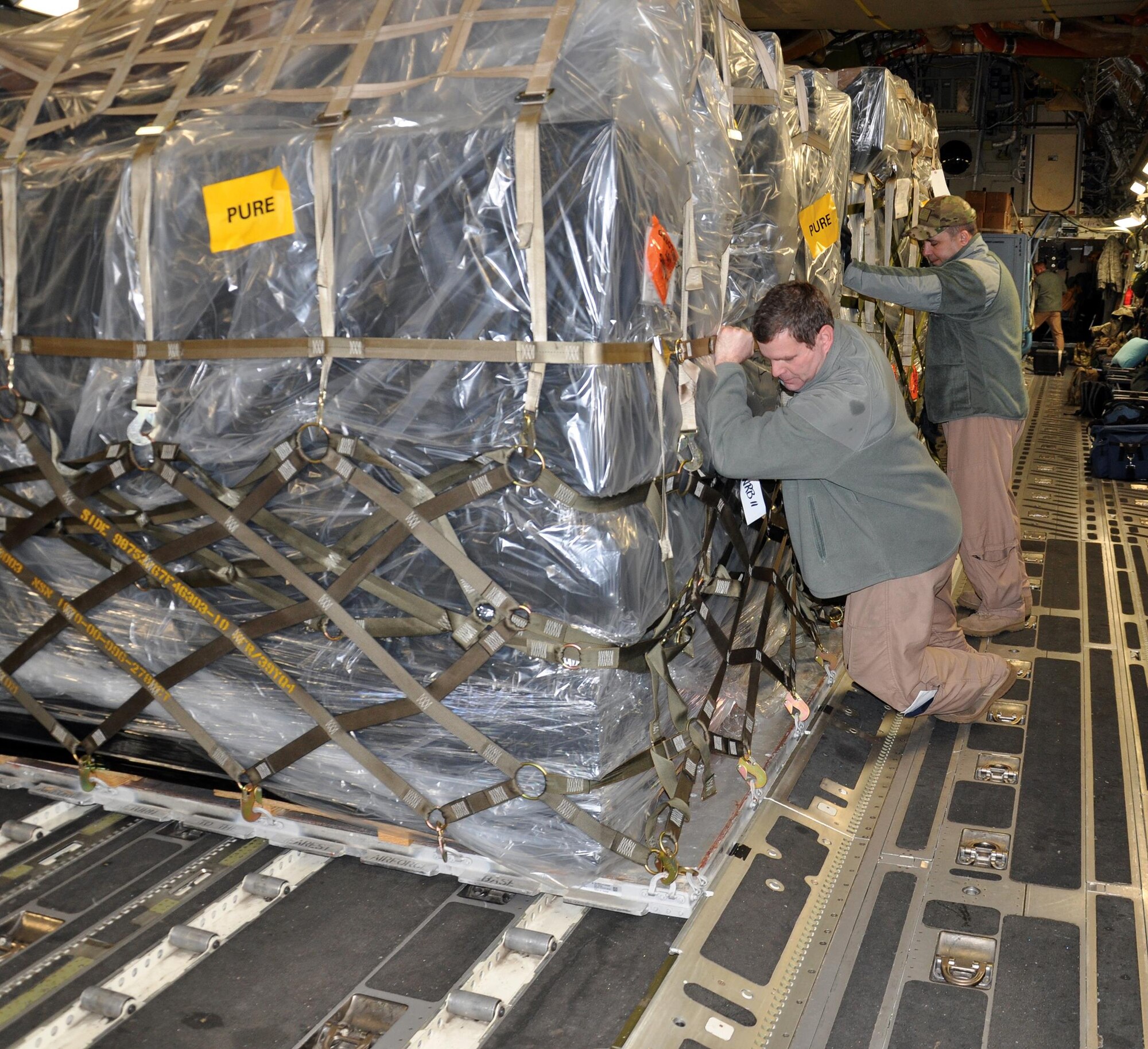 Master Sgt. Chuck Fritz (left), and Senior Master Sgt. Jason LeMaster, 89th Airlift Squadron loadmasters, unload cargo from a 445th Airlift Wing C-17 Globemaster III at Bagram Airfield, Afghanistan Jan. 2, 2015. (U.S. Air Force photo/Capt. Elizabeth Caraway)
