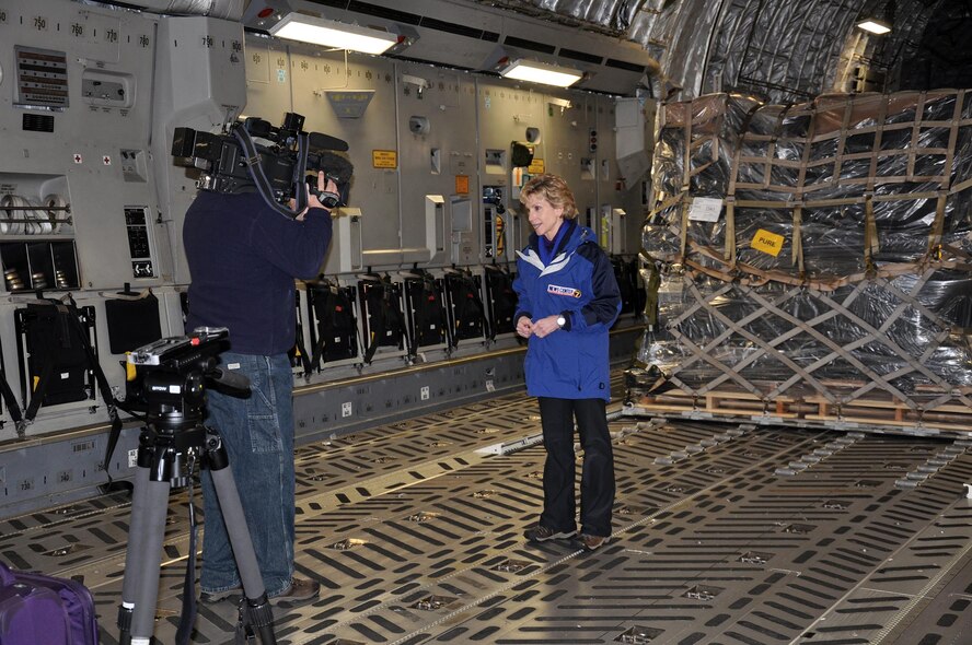 Bob Garlock, Cox Media Group videographer, films WHIO-TV Dayton, Ohio news anchor Cheryl McHenry aboard a 445th Airlift Wing C-17 Globemaster III Dec. 31, 2014. McHenry and Garlock traveled to Afghanistan from Wright-Patterson Air Force Base, Ohio via Joint Base Andrews, Maryland and Ramstein Air Base, Germany Dec. 31-Jan 4, 2015. (U.S. Air Force photo/Capt. Elizabeth Caraway)