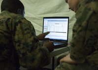 Sgt. John Waters, a field radio operator with Combat Logistics Regiment 25, 2nd Marine Logistics Group, discusses the status of communications between the units during a tent exercise aboard Camp Lejeune, N.C., Jan. 28, 2015. The Marines taking part in the exercise were tasked with keeping close tabs on the status of communications between CLR-25 and its supply and maintenance battalions. (Marine Corps photo by Pfc. Dalton A. Precht/released)