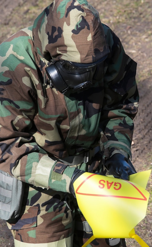 A Marine labels and places a warning sign around a contaminated area during a chemical, biological, radiological and nuclear defense training simulation aboard Naval Air Station Joint Reserve Base New Orleans, Feb. 5, 2015. Marines with the survey team are responsible for securing the perimeter and extracting any casualties. The CBRN defense training equips Marines from diverse units, with the proper knowledge and readiness needed to handle a real combat zone situation.   (U.S. Marine Corps photo by Lance Cpl. Ian Ferro)