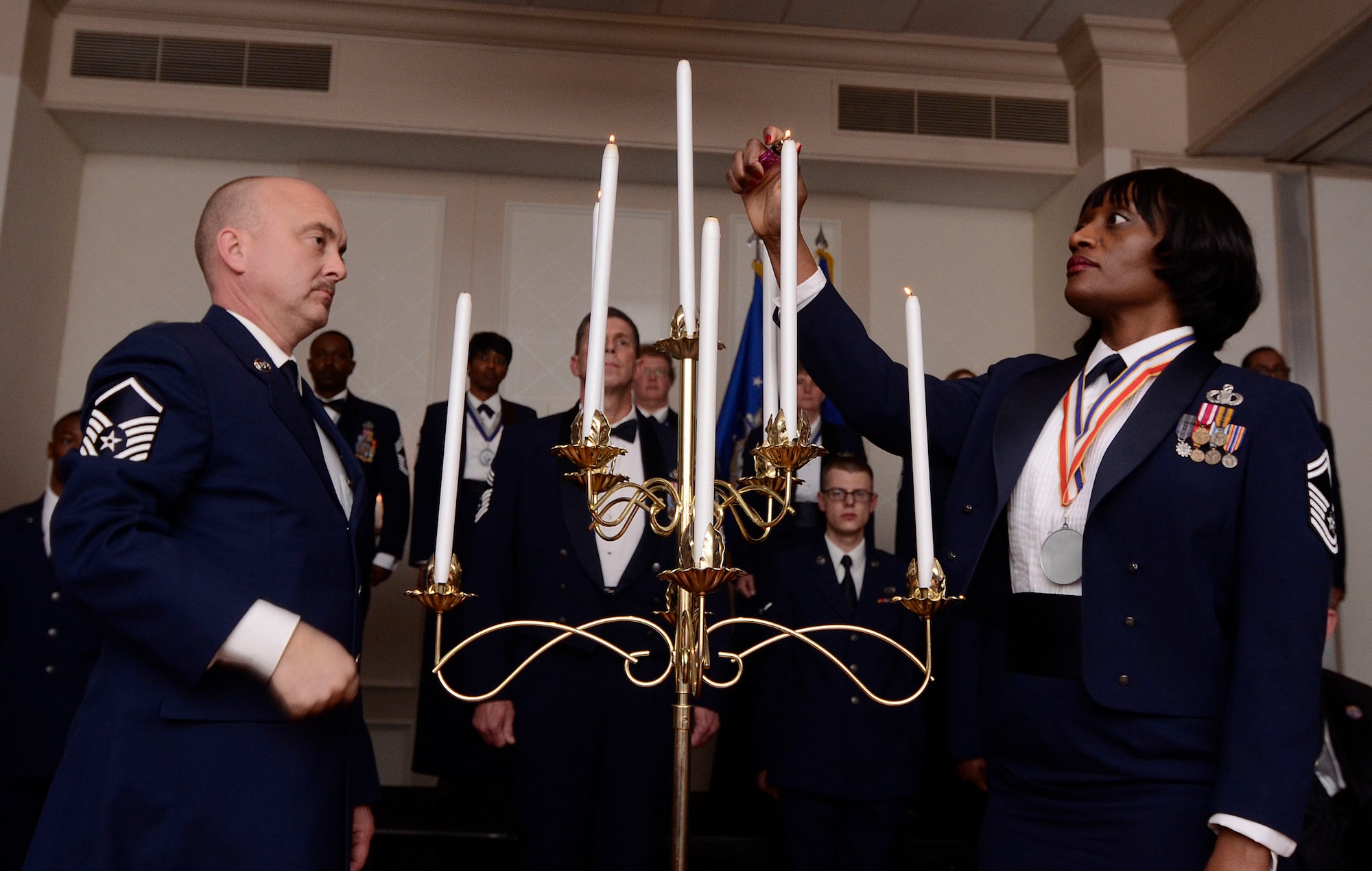 Master Sgt. Jeff Pierce, from the 94th Maintenance Squadron and Senior Master Sgt. Stephanie Gillis, from the 94th Aeromedical Evacuation Squadron, light the 7th and 8th candle, performing the Senior Noncommissioned Officer portion of the Candle Lighting Ceremony honoring newly selected Chief Master Sergeants during the First Annual Dobbins Recognition Ceremony held in Marietta, Ga. Feb. 7, 2015. The ceremony recognized individuals who demonstrated the capability to excel, and present themselves as the best of 2014. (U.S. Air Force photo/Don Peek)