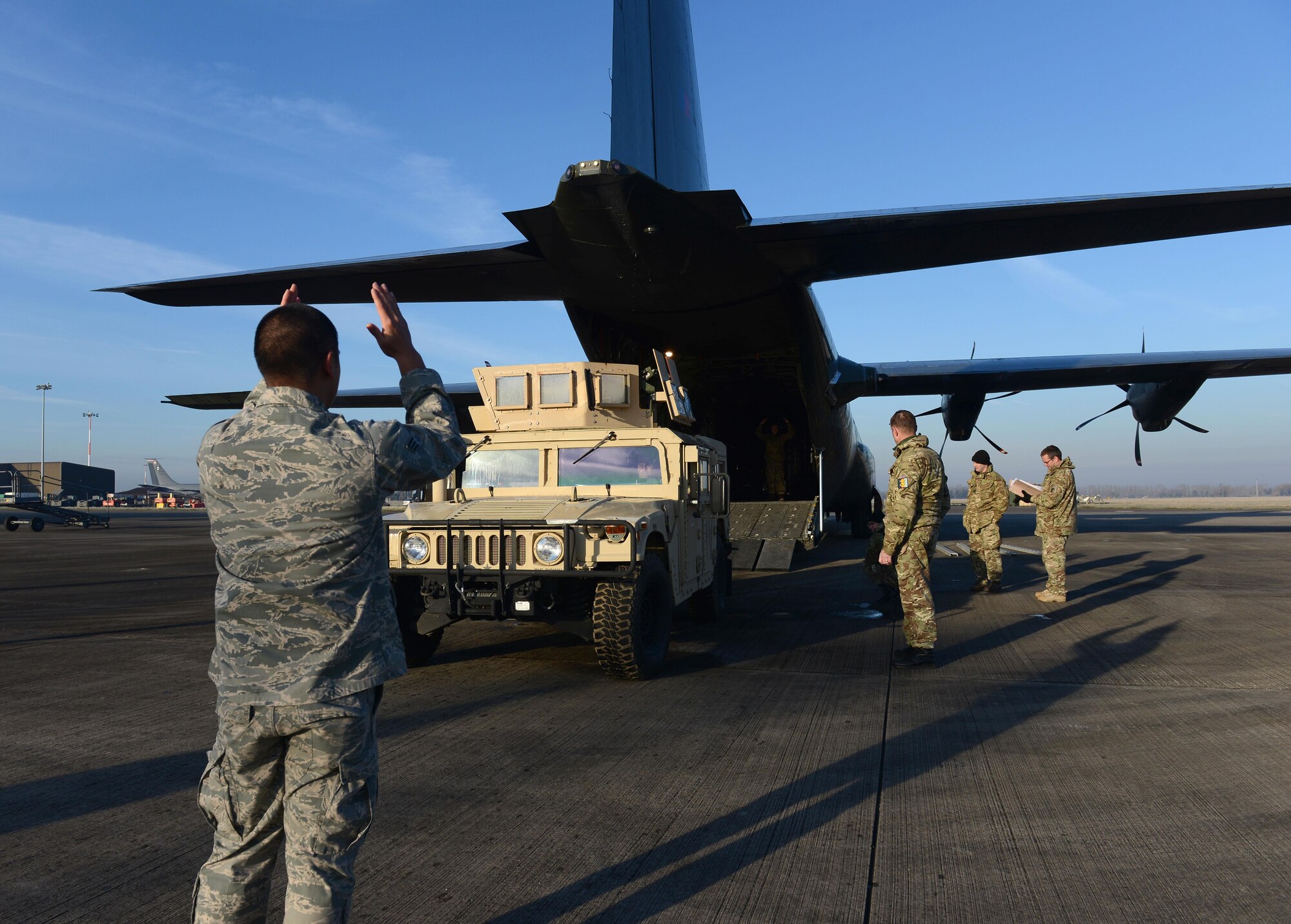 Members of the 352nd Special Operations Support Squadron deployed aircraft ground response element, work with members of the Royal Air Force to marshal a Humvee into a RAF C-130J Super Hercules during training Jan. 20, 2015, on RAF Mildenhall, England. Members of the 352nd SOSS DAGRE team worked with members of the RAF to practice loading and unloading the Humvee in preparation for their upcoming joint training exercise, Emerald Warrior, held at Hurlburt Field, Fla. (U.S. Air Force photo by Senior Airman Kate Maurer/Released)