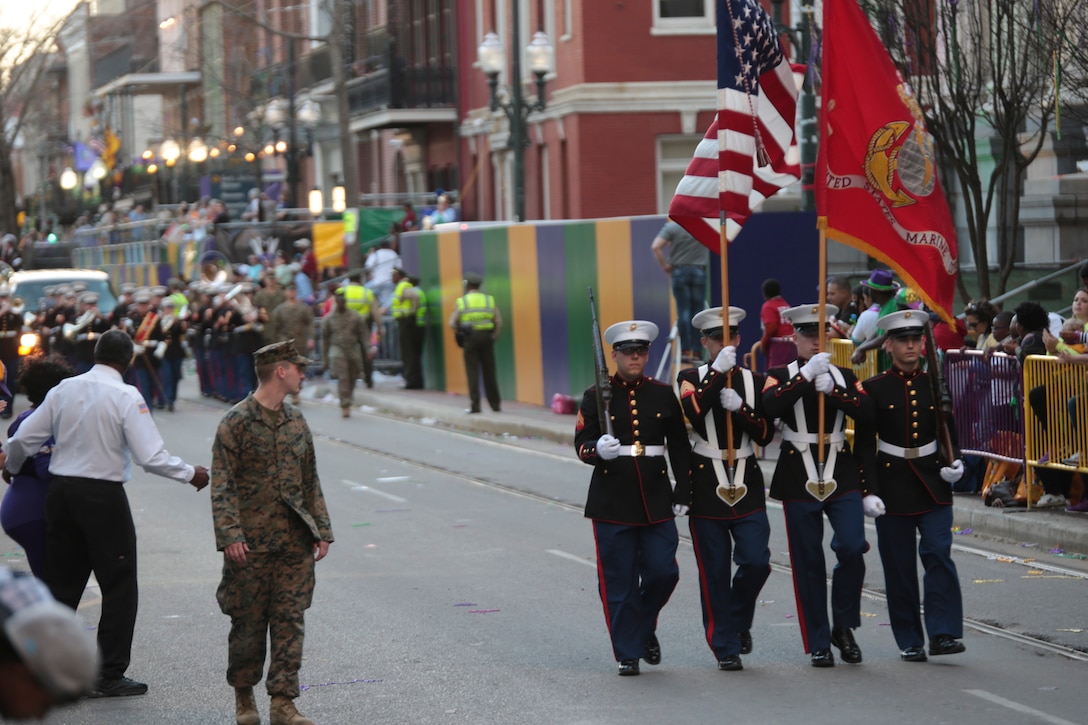 Marine Forces Reserve color guard marches in front of Marine Corps Band New Orleans with the Legion of Mars group during the Krewe of Alla Mardi Gras parade in New Orleans, Feb. 8, 2015. The Legion of Mars is the parading arm of a non-profit organization incorporated by veterans who served in Iraq and Afghanistan. The group was invited to be guest members of the parade for the second year in a row with several floats recognizing all branches and wounded veterans. (U.S. Marine Corps photo by Lance Cpl. Ian Ferro)