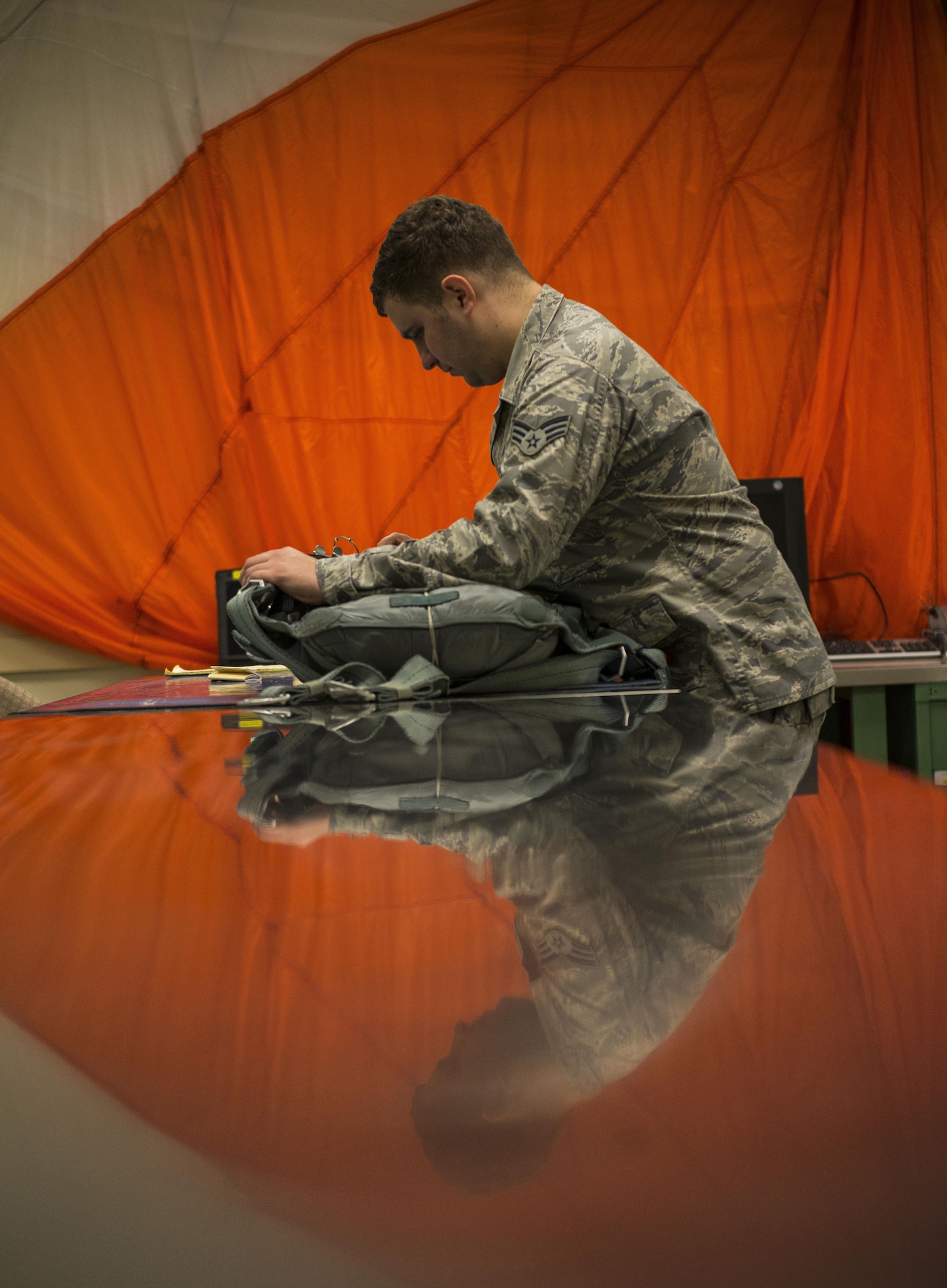Senior Airman Justin Turner  inspects a parachute before storing it for future use Feb. 9, 2015, at Joint Base Charleston, S.C. Aircrew flight equipment (AFE) technicians work through the night to provide aircrew members with safe and reliable equipment, including night vision goggles, helmets, masks and even parachutes. Turner is a 437th OSS AFE technician. (U.S. Air Force photo/Senior Airman Dennis Sloan)
