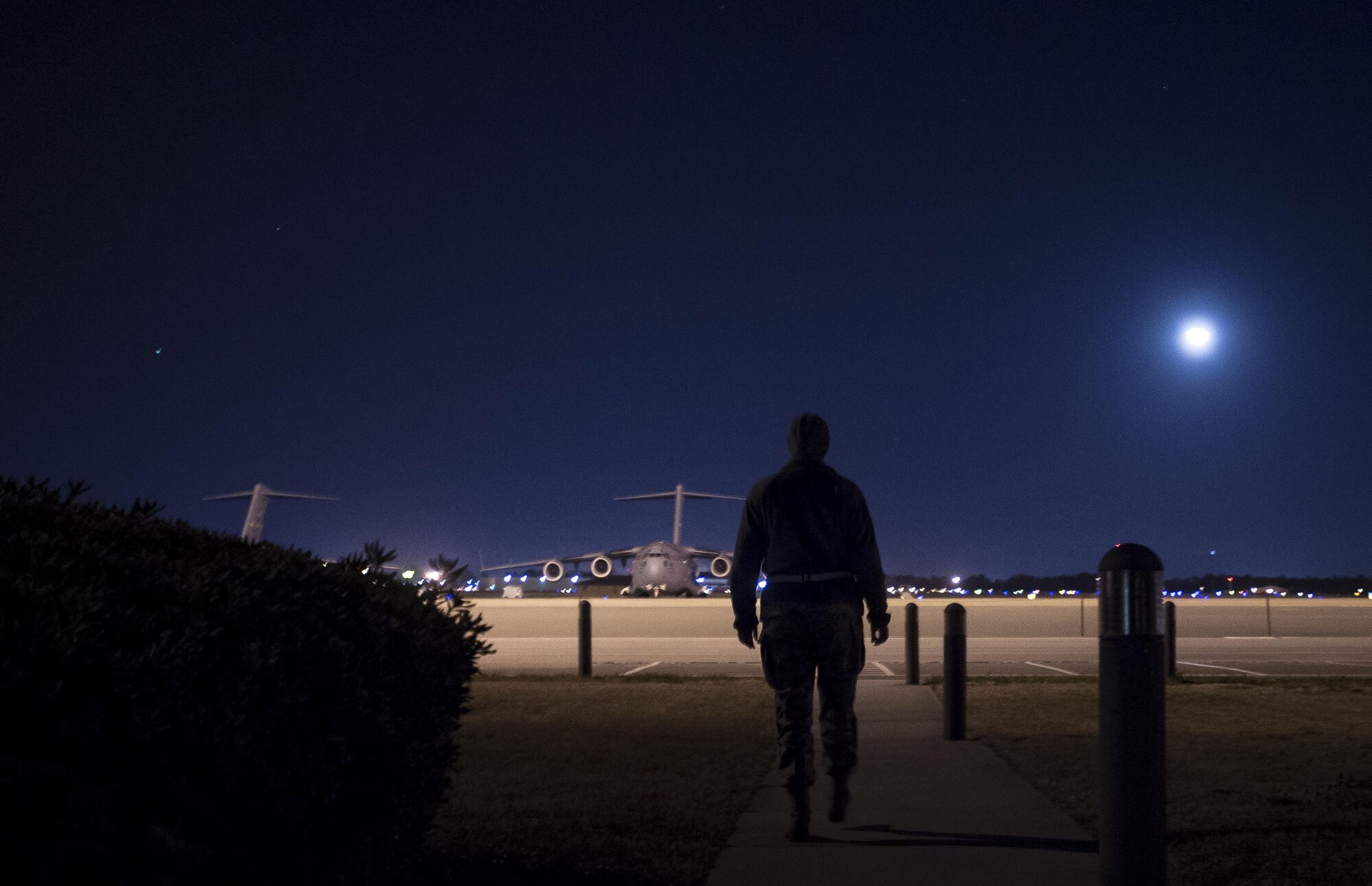Senior Airman Kathryn Raethel  walks from the base operations building out to the flightline to look for any damaged or burnt out runway lights, as well as directional signs used by aircraft Feb. 9, 2015, at Joint Base Charleston, S.C. Whenever an in-flight emergency occurs, base operations is notified and begins informing several different agencies to handle the delicate situation. Raethel is a 437th Operations Support Squadron airfield management technician. (U.S. Air Force photo/Senior Airman Dennis Sloan)