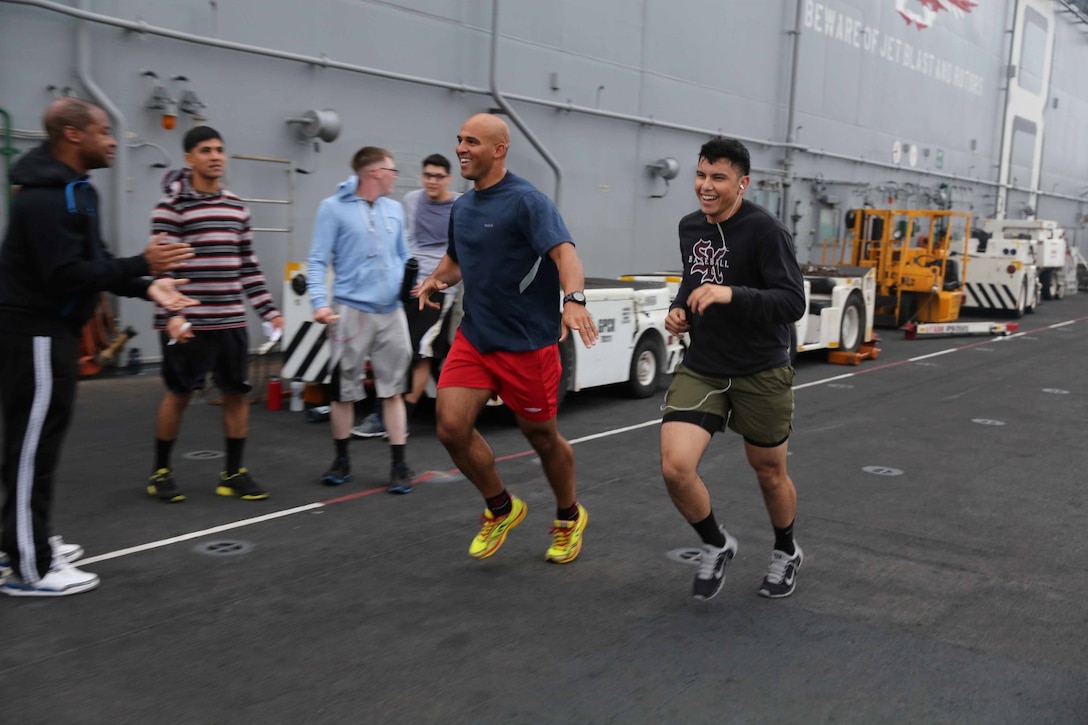 Marines and sailors with Combat Logistics Battalion, 11th Marine Expeditionary Unit, finish a 5k run as part of a CLB-11 squad competition aboard the amphibious assault ship USS Makin Island (LHD 8), Feb. 1. The Makin Island Amphibious Ready Group and the embarked 11th MEU are deployed in support of maritime security operations and theater security cooperation efforts in the U.S. 7th Fleet area of responsibility. (U.S. Marine Corps photos by Cpl. Demetrius Morgan/Released)