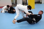 In this photo file, Pfc. Kaleb Whitten (right), an intelligence analyst with 19th Expeditionary Sustainment Command, and Onalaska, Texas native, tries to keep Ji Hoon Lee in his guard while practicing jiu jitsu at the Hoon Machado gym in Taegu, Korea, Jan. 29.