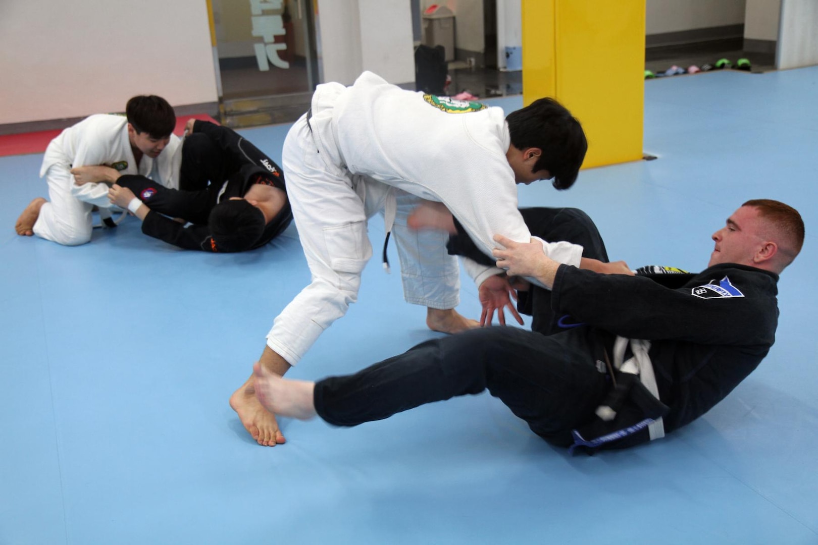 In this photo file, Pfc. Kaleb Whitten (right), an intelligence analyst with 19th Expeditionary Sustainment Command, and Onalaska, Texas native, tries to keep Ji Hoon Lee in his guard while practicing jiu jitsu at the Hoon Machado gym in Taegu, Korea, Jan. 29.
