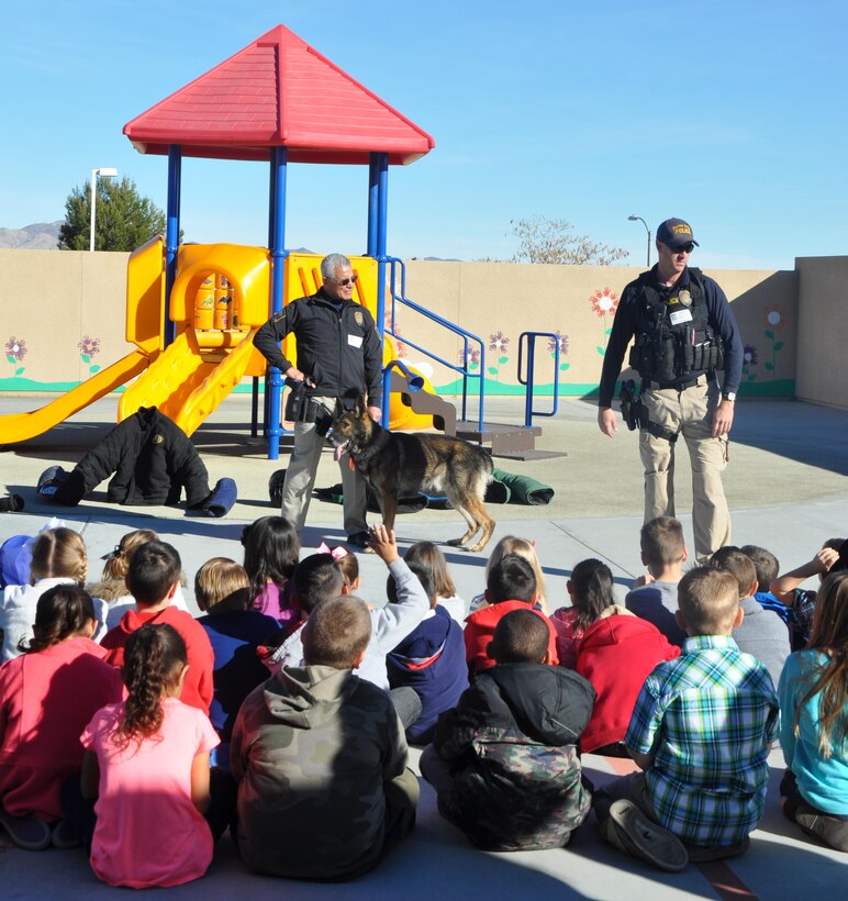 Lt. Robert Ortiz, kennel master aboard Marine Corps Logistics Base Barstow, along with Sgt. Steven Goss, K-9 trainer and K-9 officer Ricsi answer questions from students during a K-9 demonstration at Endeavor Elementary School, Feb. 4.  The officers explained how K-9 officer teams are used for patrol, protection and detection on base, in the local community and overseas. 