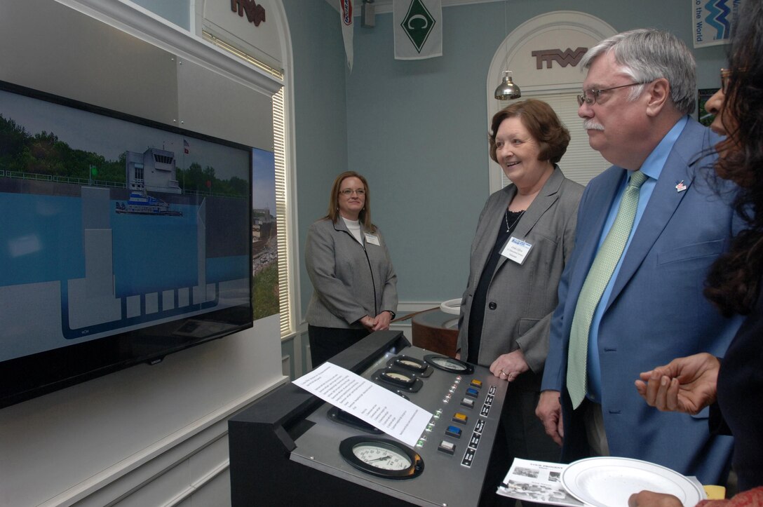 Tom Cayce, who retired as the deputy chief of Planning, Programs and Project Management for the Nashville District in 2011, works to move a tugboat through a lock on a television screen during the dedication of the Tennessee-Tombigbee Waterway Transportation Museum in Columbus, Miss., Feb. 6, 2015.