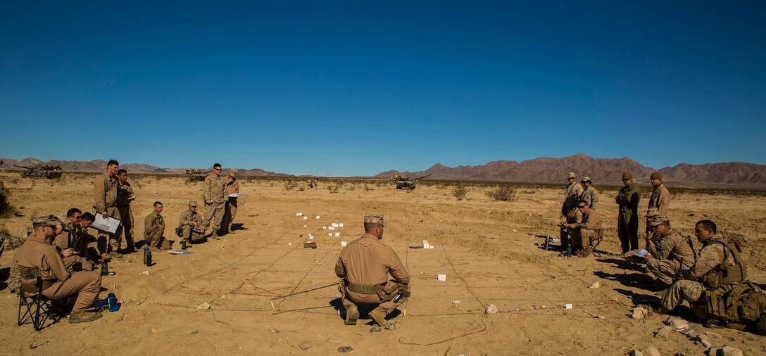 Capt. Paul B. Kozick briefs Marines from Company D Feb. 1  on the plan for the Tank Mechanized Assault Course at Marine Air Ground Combat Center Twentynine Palms as part of Integrated Training Exercise 2-15. The TMAC is a training event used to bring multiple elements of the Marine Air-Ground Task Force together in one event. Kozick, a Dillsburg, Pennsylvania, native, is tank officer and the company commander for Company D, 1st Tank Battalion, 1st Marine Division, I Marine Expeditionary Force. The Marines are also with Company D. 