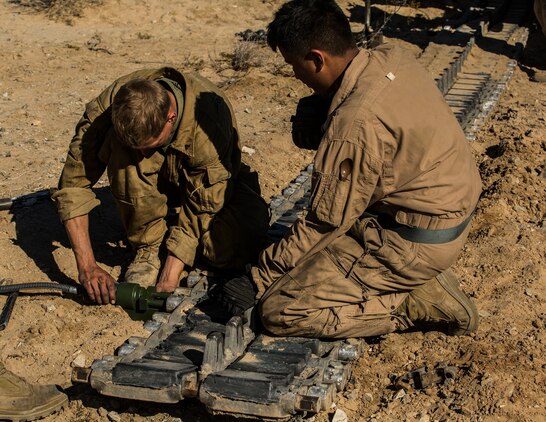Lance Cpl. Nathan C. Tucker (left) and Lance Cpl. Chue Y. Yang replace blocks for a track on an M1A1 Abrams Main Battle Tank Jan. 1 at Marine Air Ground Combat Center Twentynine Palms as part of Integrated Training Exercise 2-15. Tucker and Yang work to finish pre-mission maintenance the night before the Tank Mechanized Assault Course. The TMAC involves multiple elements of the Marine Air-Ground Task Force to accomplish an assault. Tucker, a Hamilton, Ohio, native, and Yang, a St. Paul, Minnesota, native are tank crewmen, both with  Company D, 1st Tank Battalion, 1st Marine Division, I Marine Expeditionary Force. 