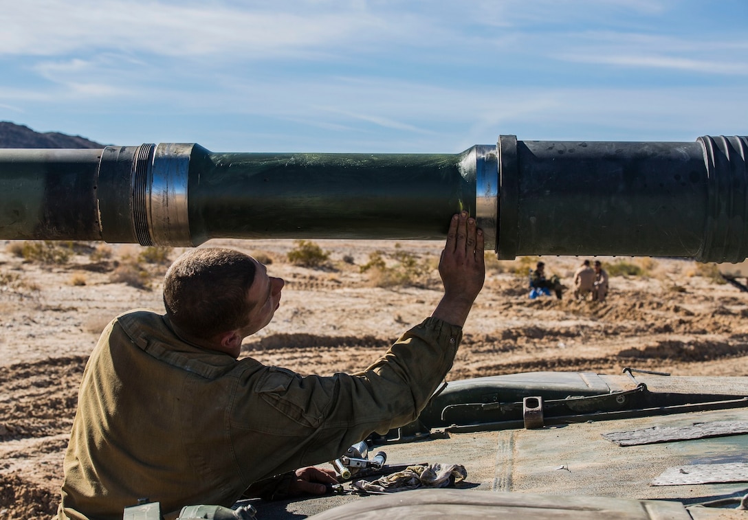 Pfc. Dylan F. McVey greases the bore evacuator on the M1A1 Abrams Main Battle Tank to allow the weapon to fire smoothly Jan. 1 at Marine Air Ground Combat Center Twentynine Palms as part of Integrated Training Exercise 2-15. McVey performs maintenance on his tank the night prior to the Tank Mechanized Assault Course. The TMAC incorporates multiple elements of the Marine Air-Ground Task Force for training during ITX 2-15. McVey, a Staten Island, New York, native, is a tank crewman with Company D, 1st Tank Battalion, 1st Marine Division, I Marine Expeditionary Force. 
