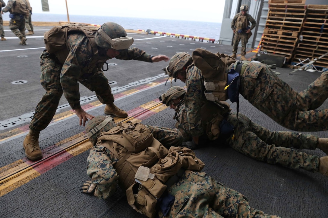 Marines with Golf Company, Battalion Landing Team 2nd Battalion, 1st Marines, 11th Marine Expeditionary Unit, conduct combat conditioning during a deck shoot aboard the amphibious assault ship USS Makin Island (LHD 8), Feb. 1. The Makin Island Amphibious Ready Group and the embarked 11th MEU are deployed in support of maritime security operations and theater security cooperation efforts in the U.S. 7th Fleet area of responsibility. (U.S. Marine Corps photos by Cpl. Demetrius Morgan/Released)   