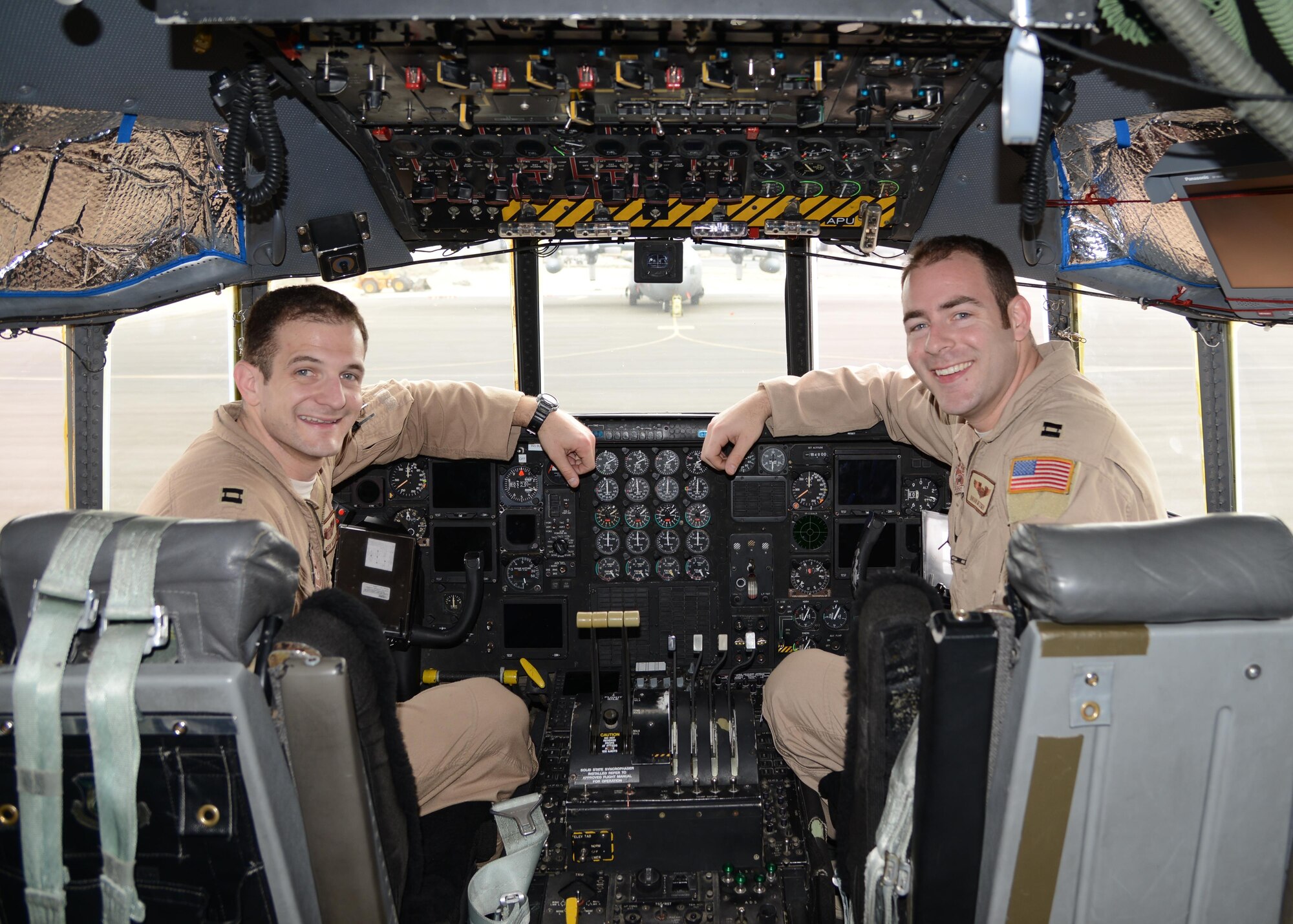 Capt. Andrew Metzger (left) and his brother Capt. Brian Metzger sit in the cockpit of a C-130H here Feb. 7, 2015.  Andrew is a C-17 pilot stationed at Charleston Air Force Base, South Carolina, and Brian is an Air Force Reserve C-130 Hercules pilot deployed from Dobbins Air Reserve Base, Georgia. (U.S. Air Force photo by 1st Lt. Sarah Ruckriegle)