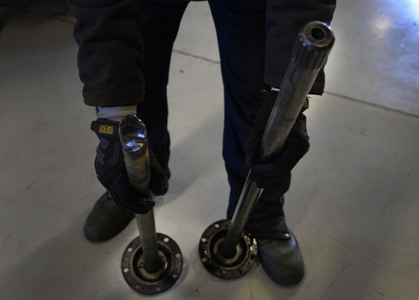 Airman 1st Class Joshua Davis, 27th Special Operations Logistics Readiness Squadron fire truck mechanic, demonstrates the difference between a serviceable and non-serviceable real axle Feb. 5, 2015 at Cannon Air Force Base, N.M. Vehicle maintainers cut costs and save the wing countless dollars by utilizing salvaged components when repairing vehicles in the Cannon fleet. (U.S. Air Force photo/Staff Sgt. Alexxis Mercer)